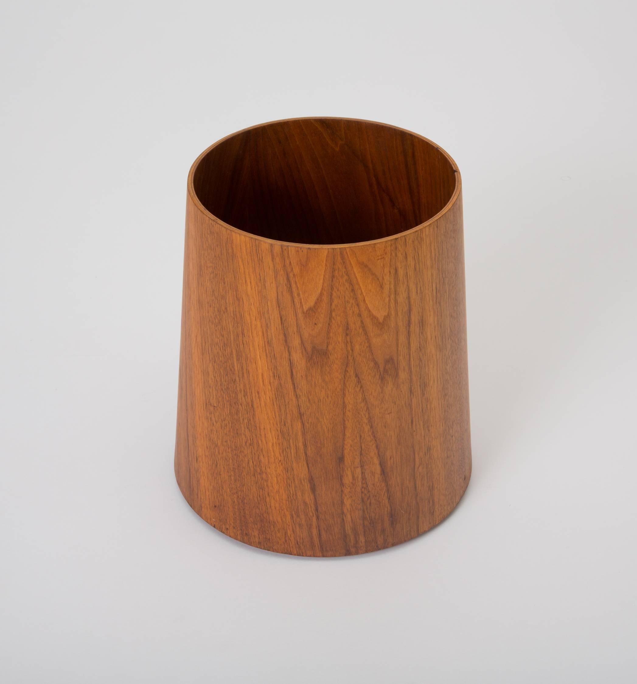 From a line of Jens Risom office accessories manufactured by his company, Jens Risom Design, this walnut wastebasket has a wide base and tapers at a gentle angle toward the mouth of the receptacle. The canister’s interior is finished in walnut