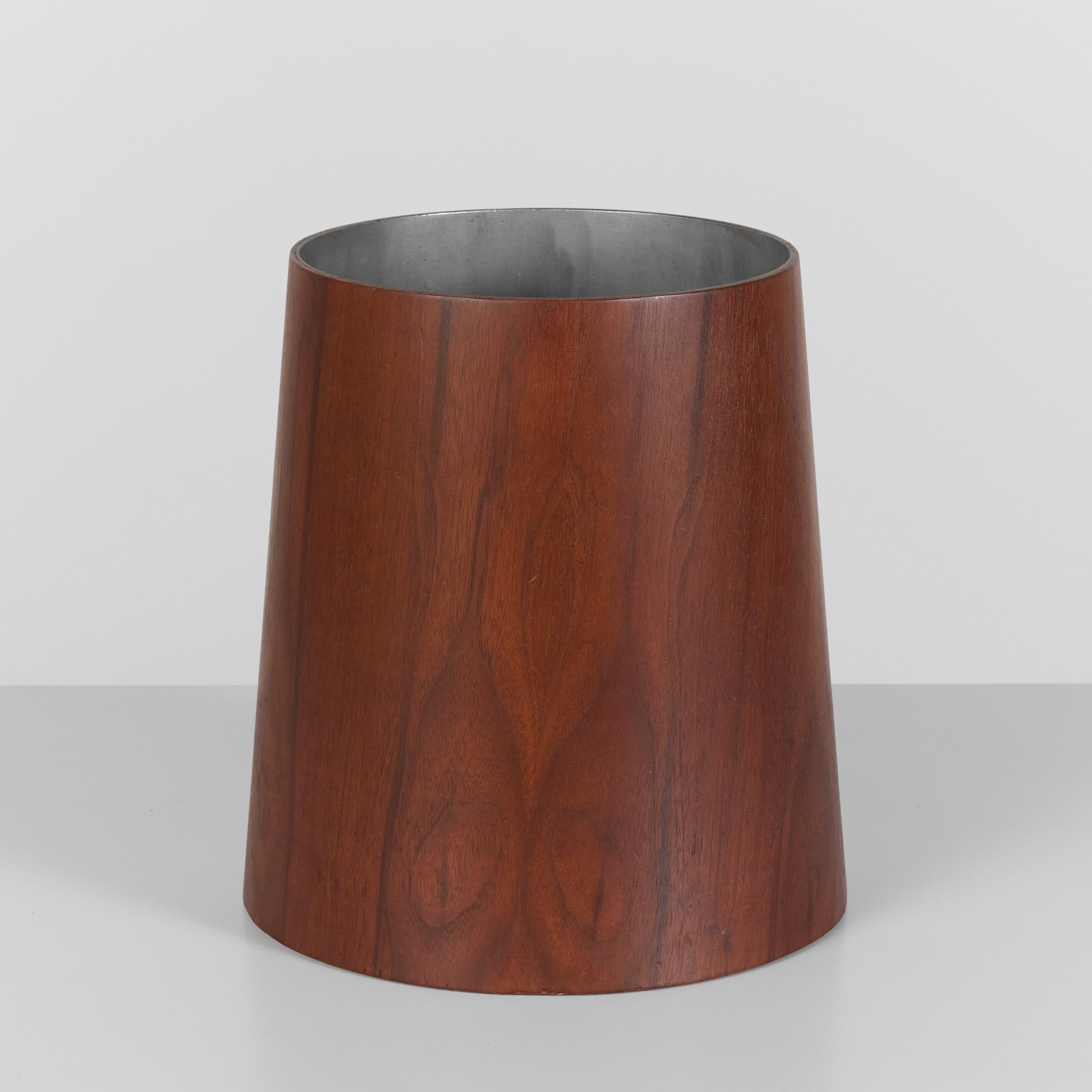 From a line of Jens Risom office accessories manufactured by his company, Jens Risom Design, c.1950s, this walnut wastebasket has a wide base and tapers at a gentle angle toward the mouth of the receptacle. The canister’s interior is finished in