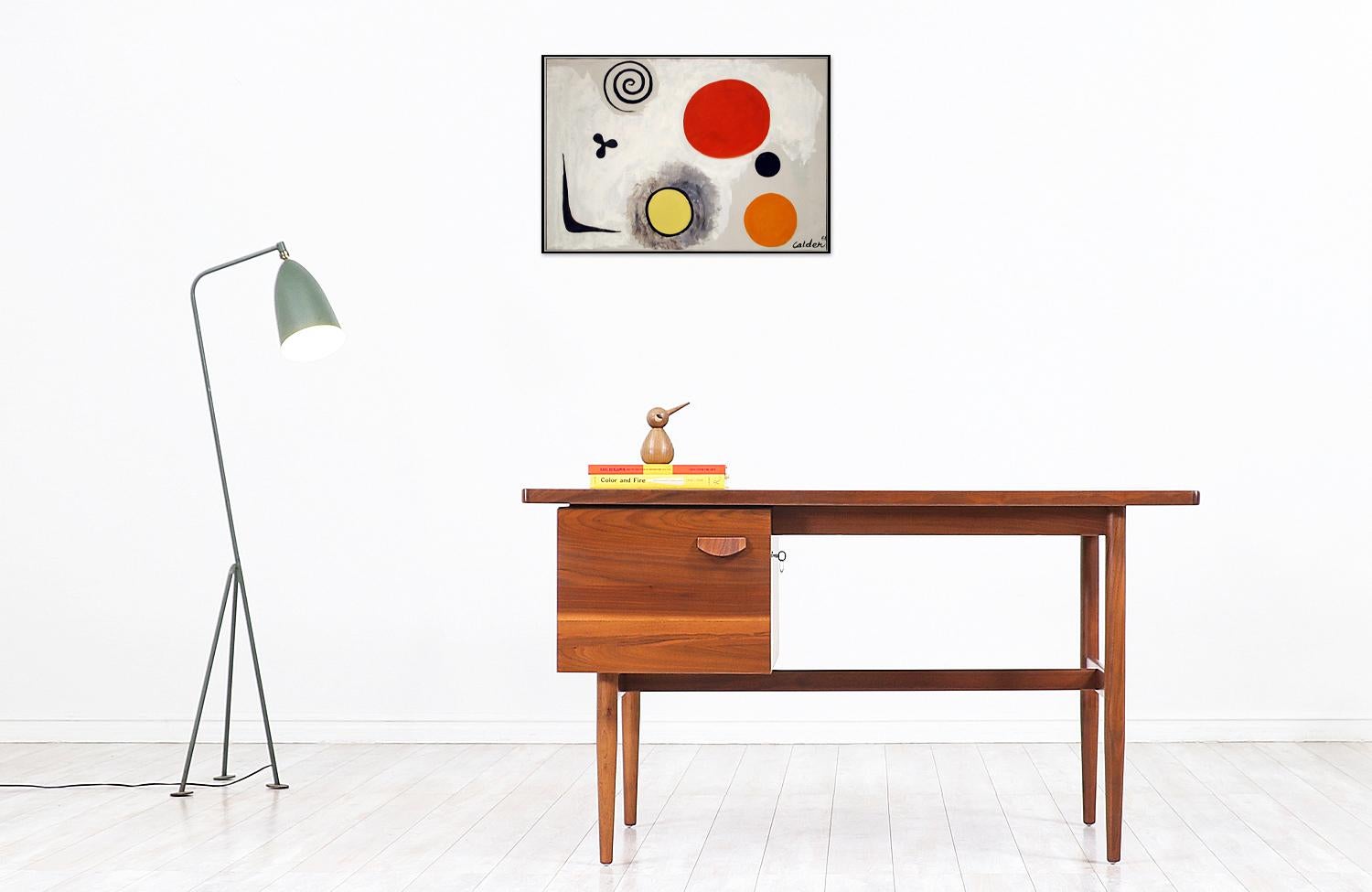 Elegant modern writing desk designed by Jens Risom for Jens Risom Inc. in the United States circa the 1950s. This stylish desk features a walnut wood frame and a file cabinet on the right side for ample storage space. The drawer has a sculpted