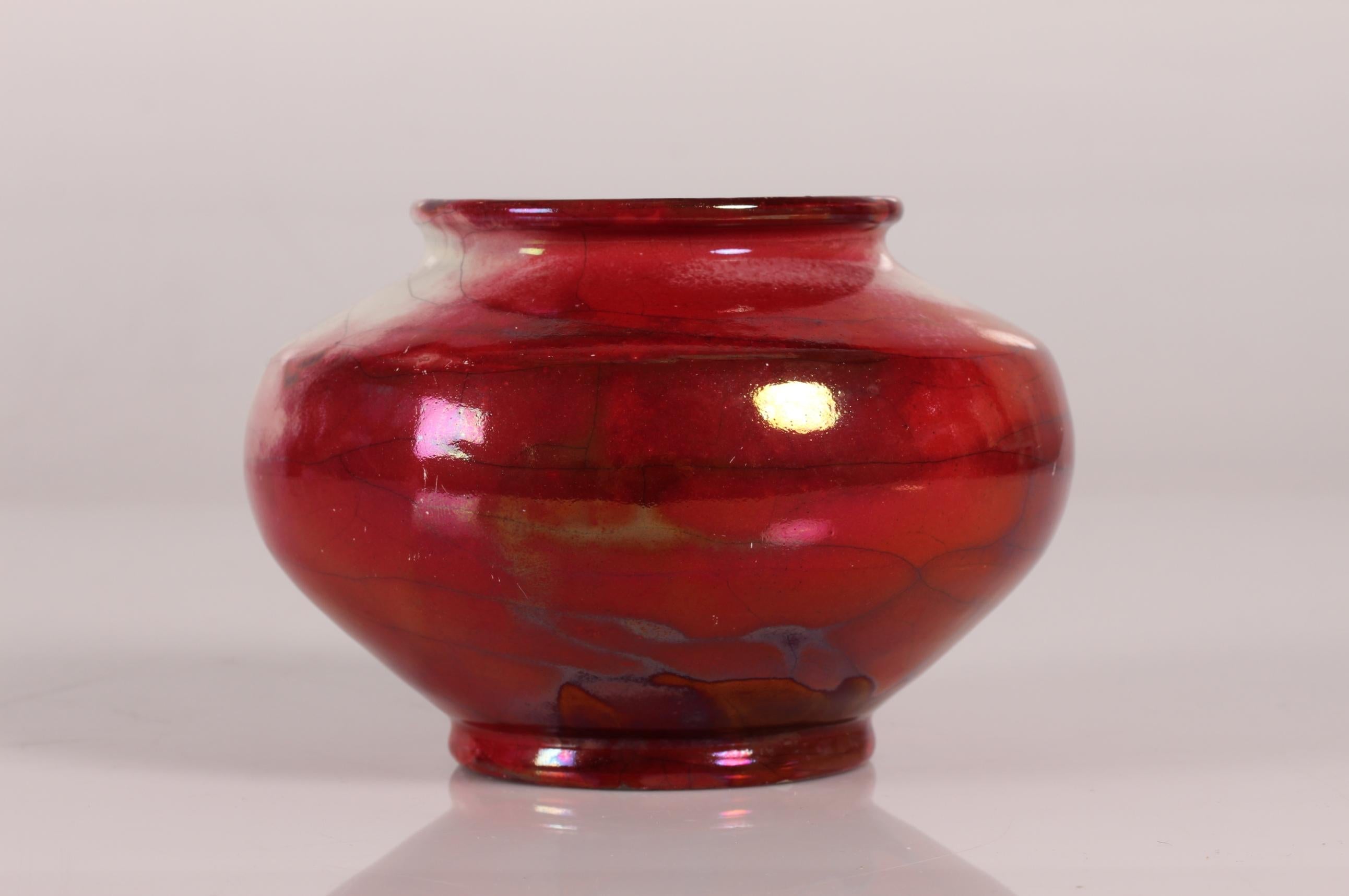 Round ceramic vase by Jens Thirslund made at Herman A. Kählers ceramic workshop in the 1920s

The vase is decorated with a shiny and smooth luster glaze, primarily red but with a tough of white, and is signed HAK + V + Denmark

Measures: Height