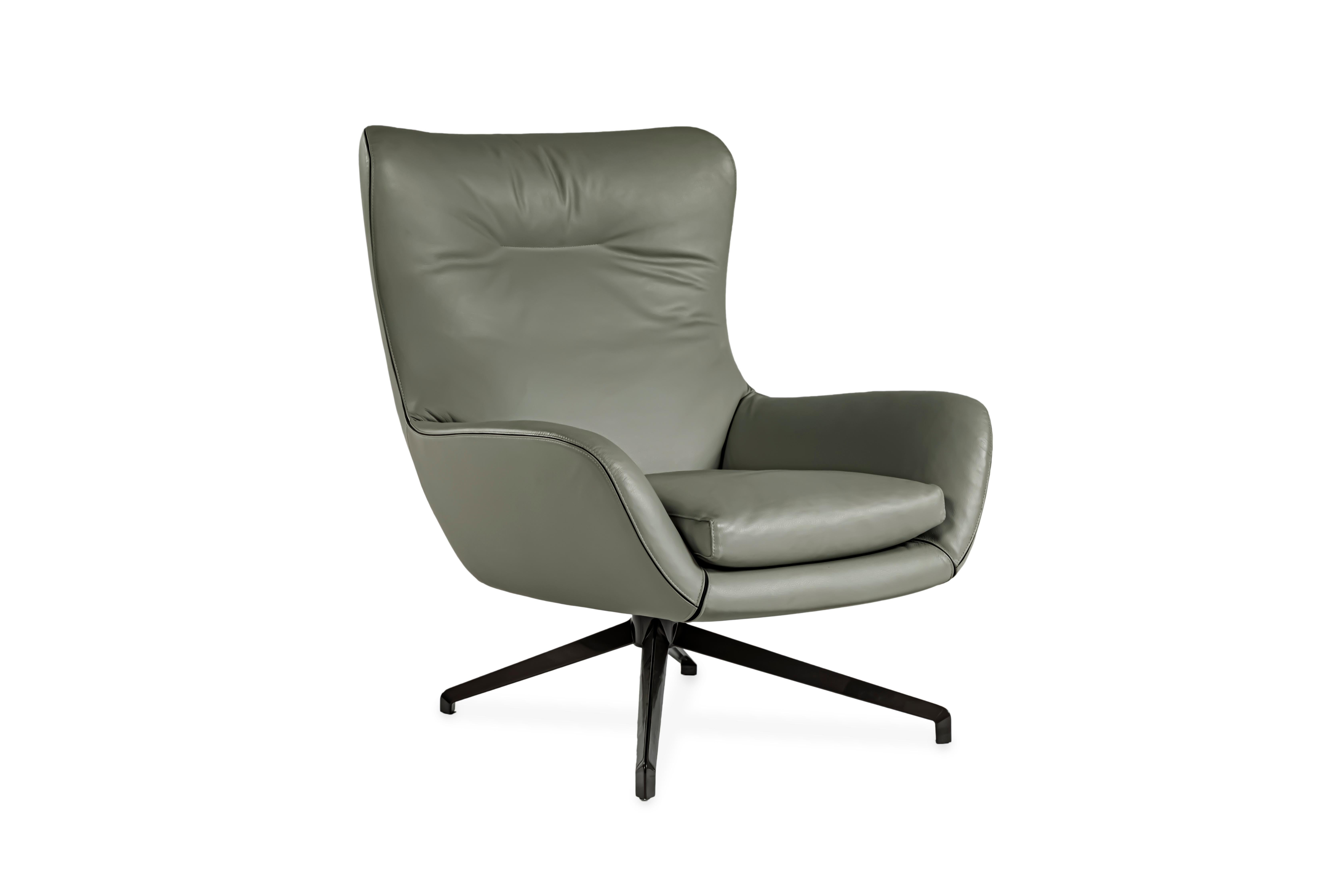 A winged lounge chair upholstered in gray leather, with black fabric piping. The armchair sits on an aluminum base with a pewter finish. 

