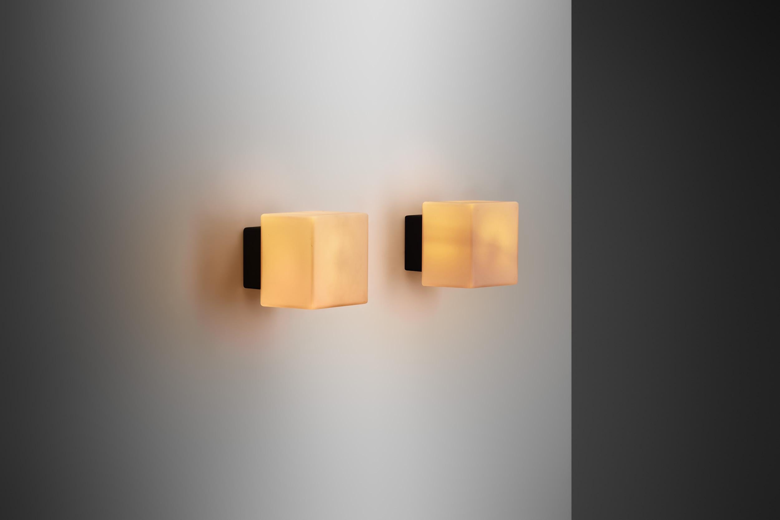 This pair of Louis Poulsen produced “Kubuarmatur” or cube lamps, more specifically known as “model 38117” wall lamps are quintessential representations of Danish modern design, characterized by simplicity, functionality, and a distinct minimalist