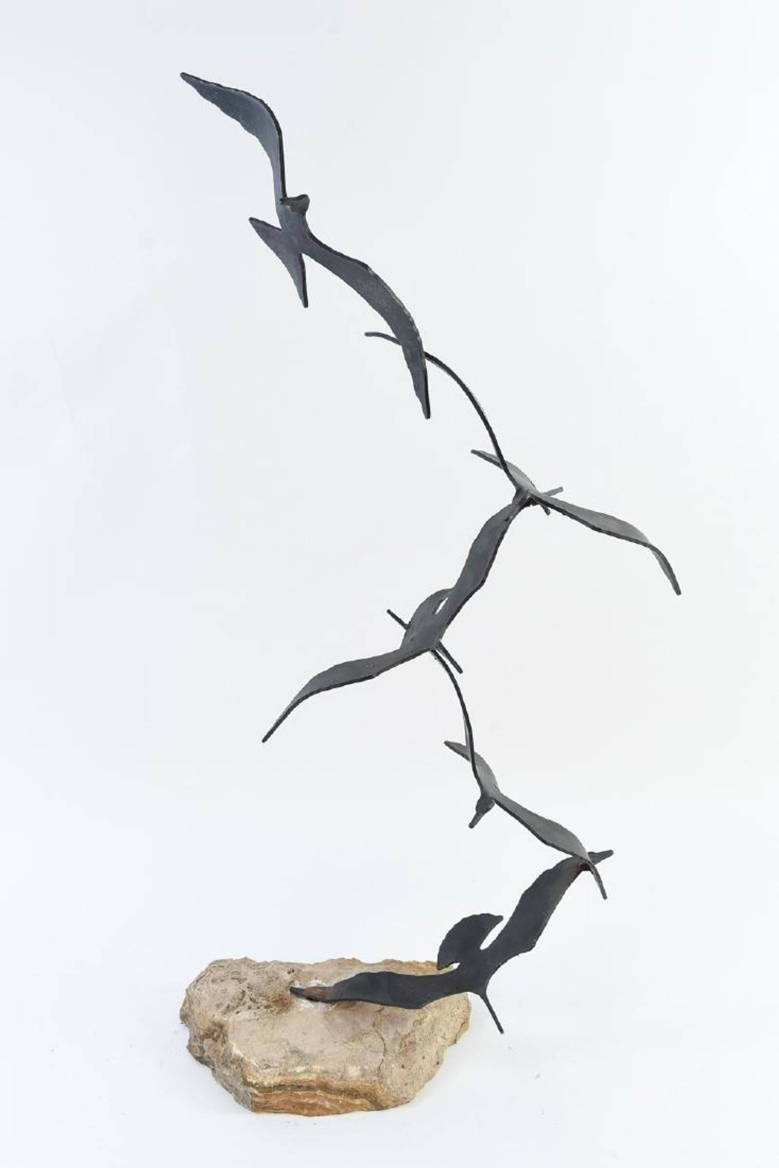 A Mid-Century Modern Curtis Jere sculpture. Welded metal flock of birds sculpture mounted on a natural stone. The birds are in a flat black finish and retain the artist signature and date on one of the wings.