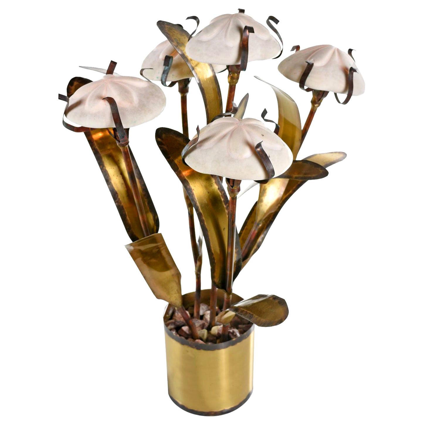 A fantasy underwater seascape of organic floral sculpture made of patinated metal with copper, steel, gold and brass tones. Five stems rise from the pot and are each topped with a single light bulb. Authentic sea urchin shells act as lamp shades and