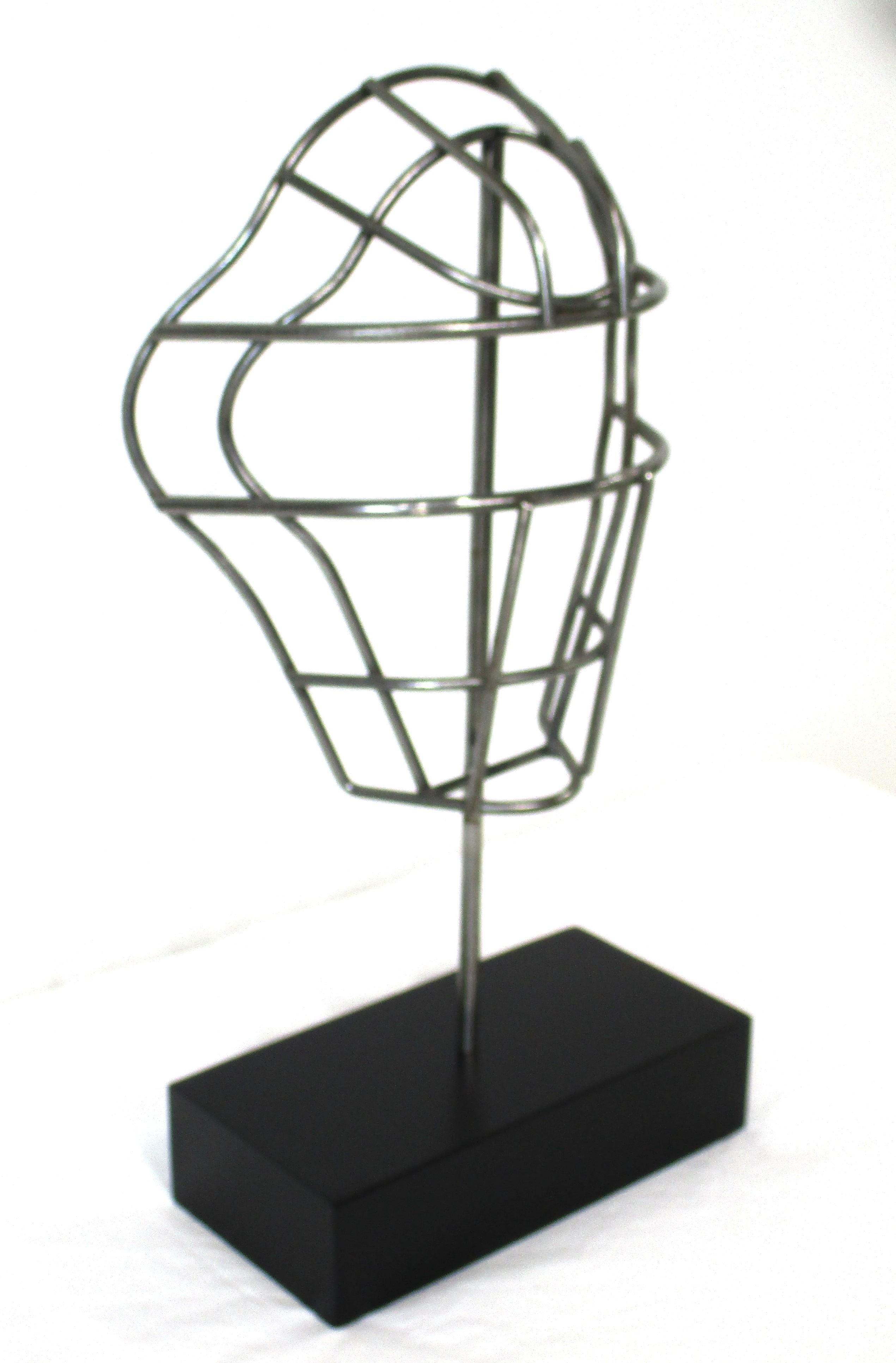 Una maschera da ricevitore in stile Curtis Jere per l'atletica, il lacrosse o il baseball, montata su una pesante base in metallo nero satinato come pezzo d'arte e scultura. Realizzato in acciaio grezzo, è perfetto per l'area sportiva, il bar, il