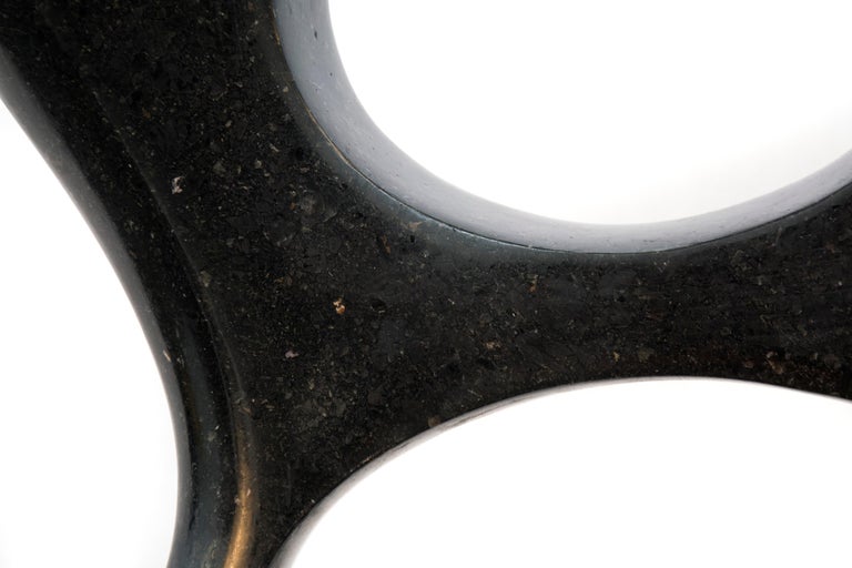 Smooth surfaced, black granite has been engineered into an elegant figure eight shape by sculptor Jeremy Guy. Poised on a flat, brushed aluminum base, the sculpture tapers slightly at the top. Sculpture including base weighs 85 lbs. This work is