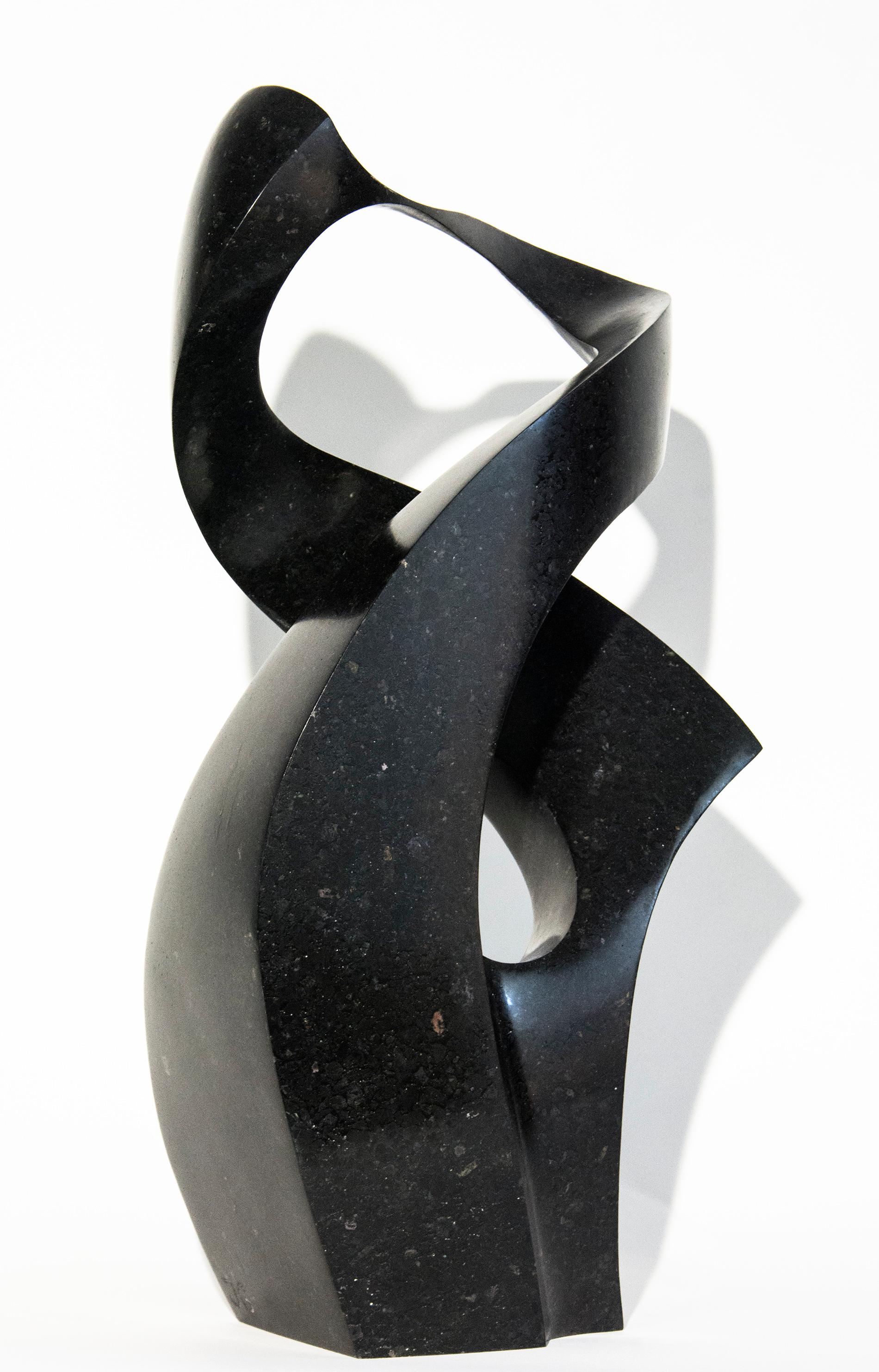 Die lyrische und bewegende abstrakte Darstellung einer menschlichen Umarmung des Bildhauers Jeremy Guy ist aus schwarzem Granit gefertigt. Zwei sanft geschwungene Formen verflechten sich in dieser zeitgenössischen Tischskulptur, die auf eine Auflage
