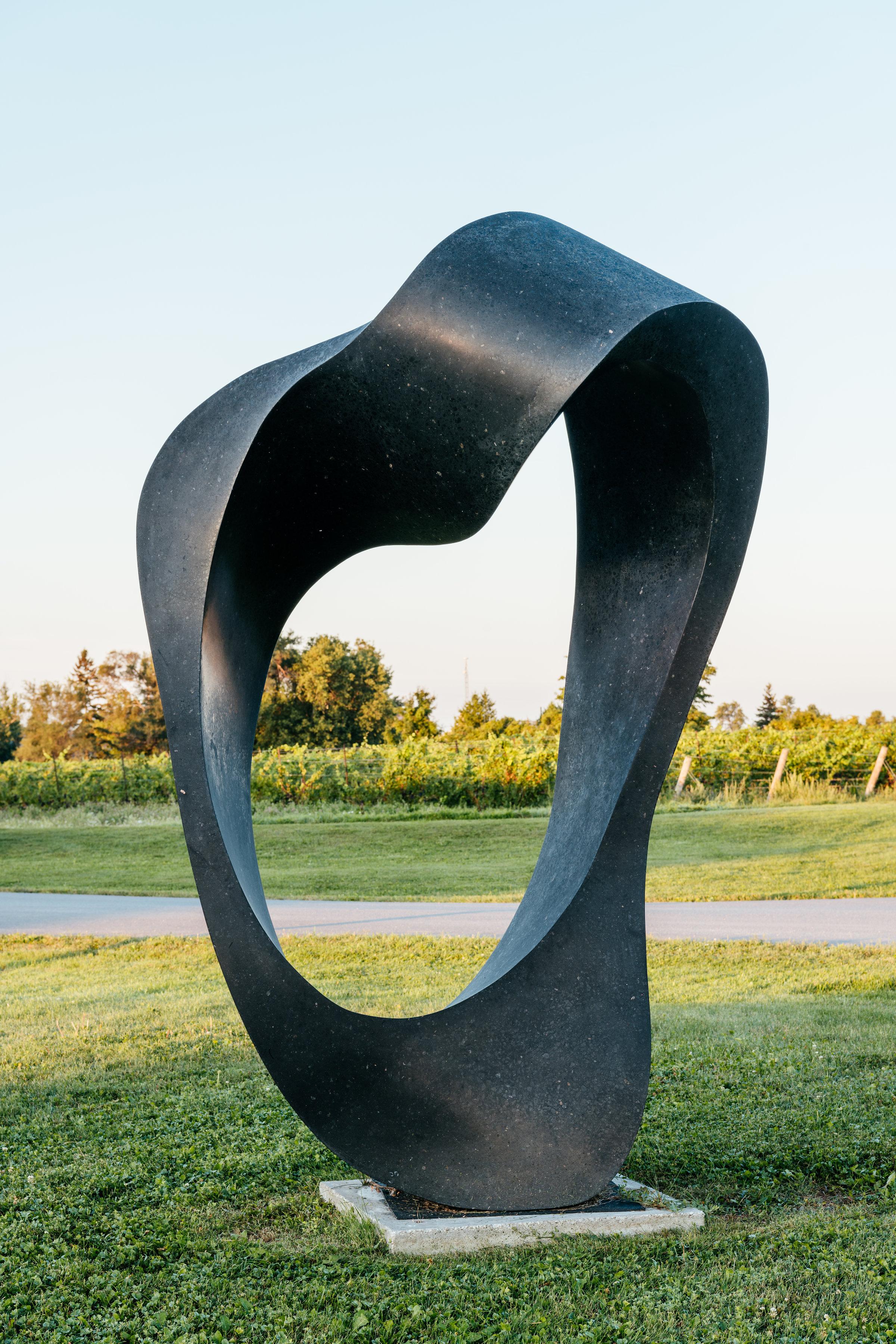 Jeremy Guy esculpe granito negro de ingeniería en una elegante abstracción arremolinada inspirada en el comportamiento de bandada de los estorninos. Llamada murmuración, este fenomenal ballet aéreo parece como si los pájaros fueran una única masa