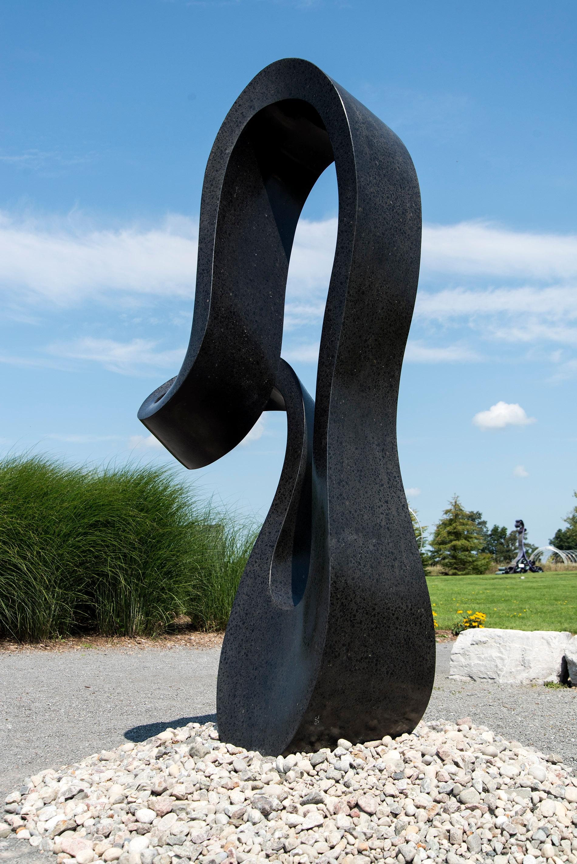 Smooth black granite engineered to resemble a time signature in music becomes an elegant outdoor sculpture by artist Jeremy Guy. 

