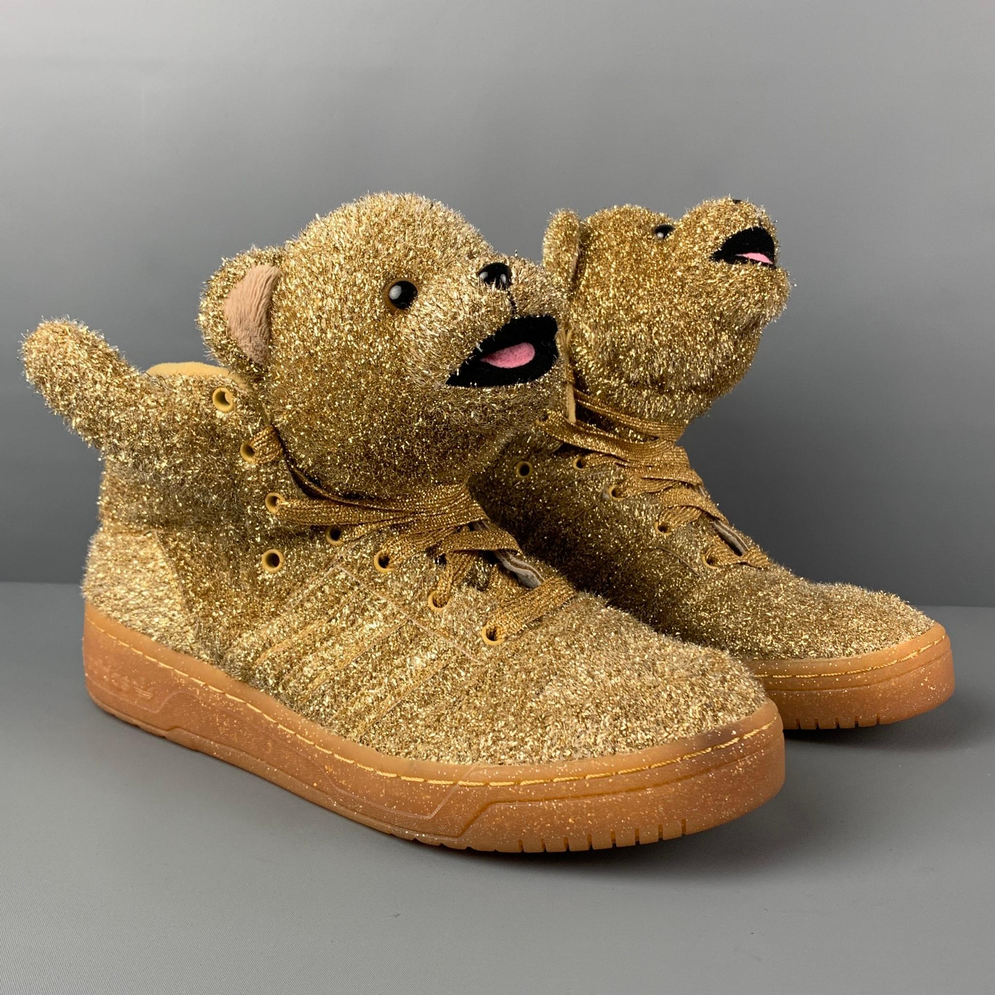 JEREMY SCOTT x ADIDAS sneakers comes in a metallic tinsel gold featuring a high top style, bear design, rubber sole, and a lace up closure. 

Very Good Pre-Owned Condition.
Marked: 11

Outsole: 12.25 in. x 4 in.