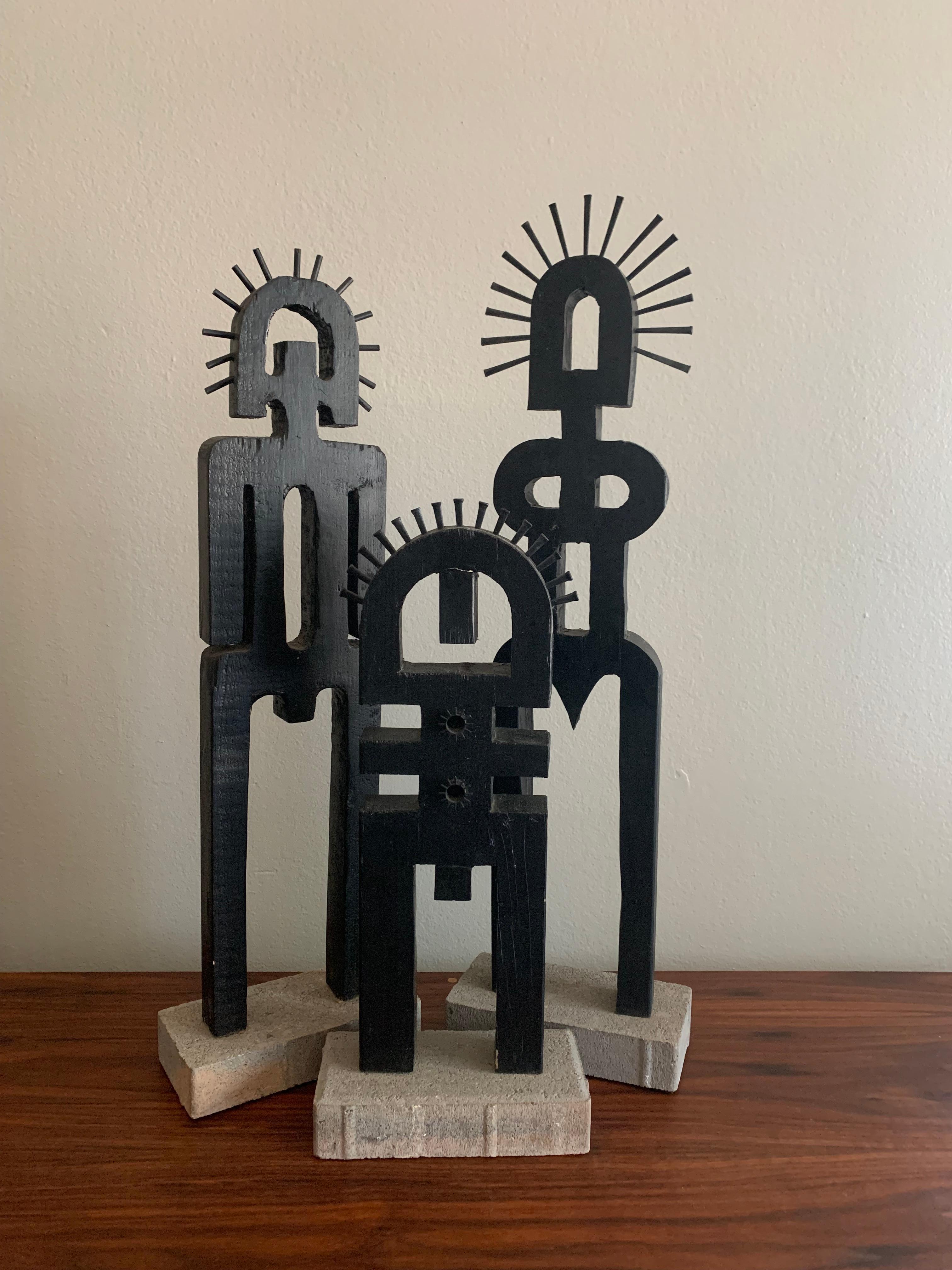 Naive in nature, this set of 3 figures by Ohio artist Jeri Summers is reminiscent of tribal sculptures that decorate Parisian interiors. Each sculpture is comprised of painted wood with metal accents and set upon a concrete base.

Tall figure: 27