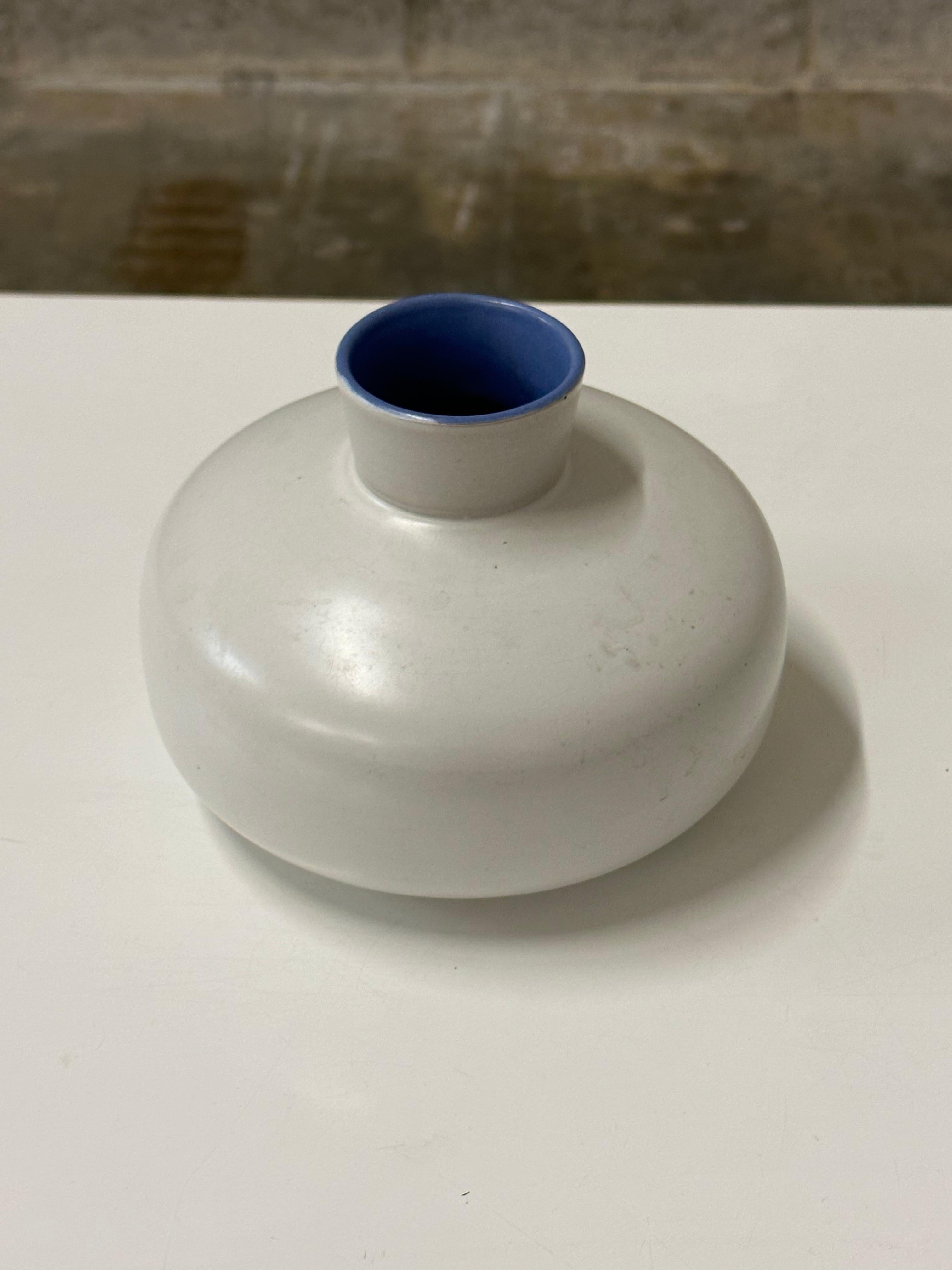 An unusual low and wide vase by Jerk Werkmäster for Nittsjö. Features a squat body and short neck with very interesting interior color of blue vs the flat white body. A very unique shape and color. Signed JW on underside.