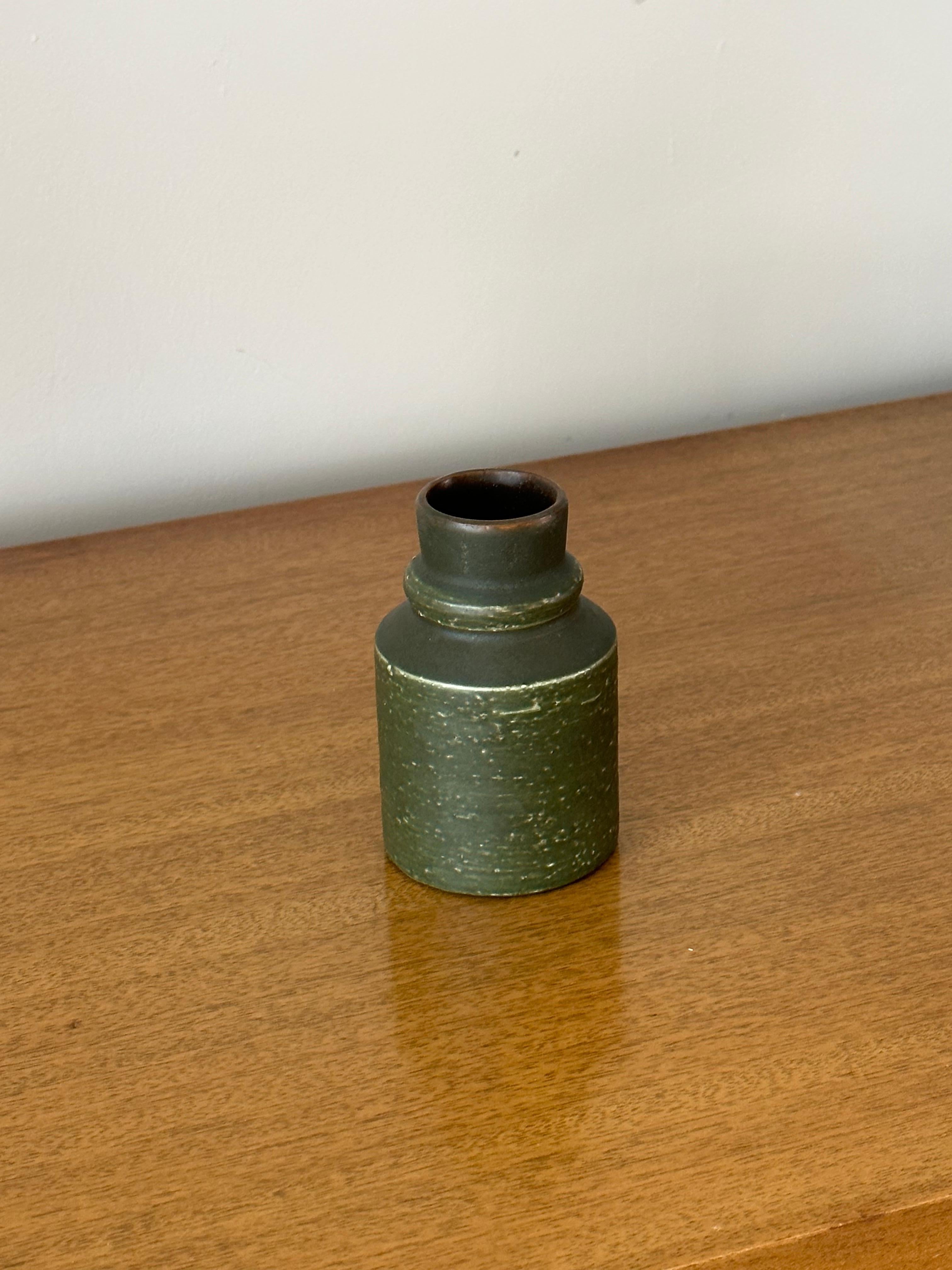 Vaso senza tempo progettato da Jerk Werkmäster e prodotto da Nittsjö. Il corpo è di colore verde militare con sfumature marroni. È molto attuale oggi come lo era quando è stato realizzato. 