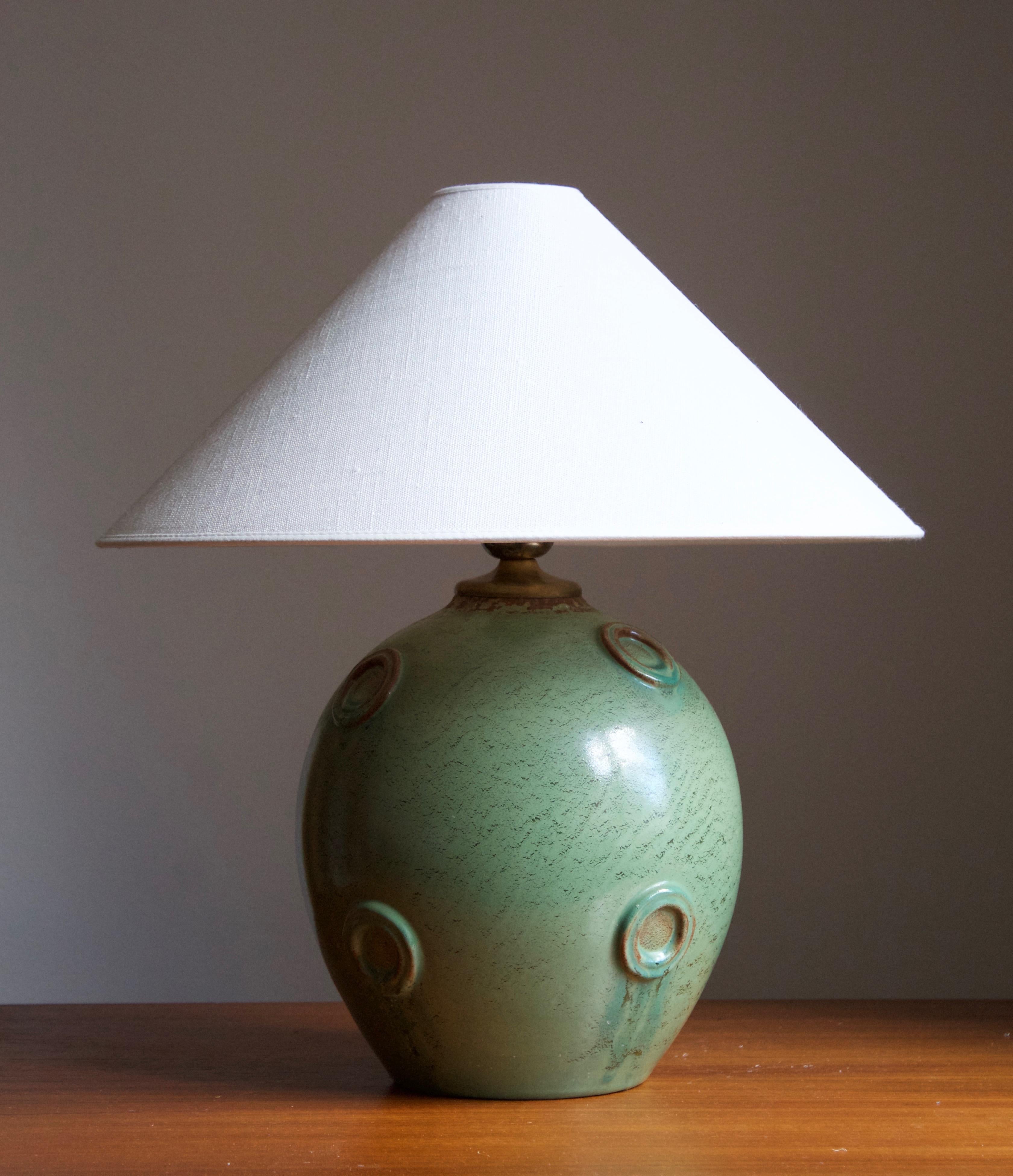 A large modernist table lamp designed by Jerk Werkmäster. Produced by Nittsjö, Sweden, 1930s. Stamped.

Stated dimensions exclude the lampshade. Sold without lampshade.

Glaze features a green color with hints of brown.

Other designers of the