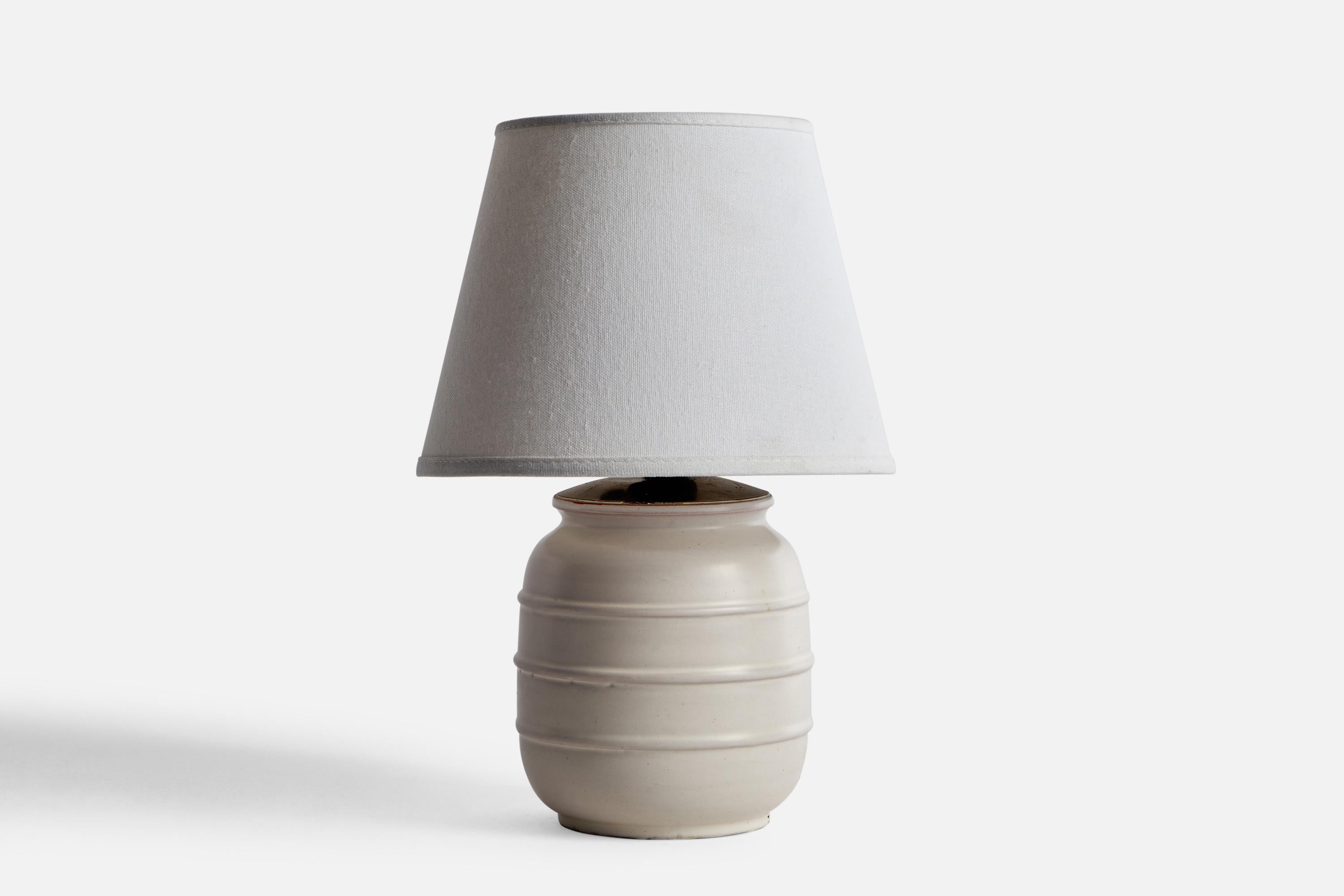 A light-grey ceramic and brass table lamp designed by Jerk Werkmäster and produced by Nittsjö, Sweden, c. 1930s.

Dimensions of Lamp (inches): 9” H x 5” Diameter
Dimensions of Shade (inches): 4.5” Top Diameter x 10” Bottom Diameter x 5.25”