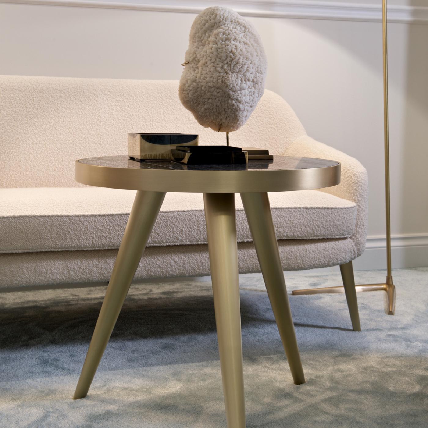 Part of the Jerome collection, this side table is a versatile and charming addition to a modern interior. Its slanted, tapered legs are a homage to mid-century charm and are crafted of satin-finished brass. The same elegant metal is the mounting for