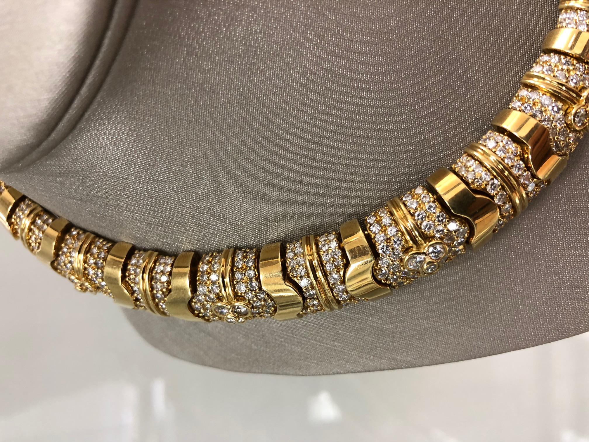 The collar necklace, crafted in 18K gold,  choker length, is set with approximately 1040 full cut round diamonds totaling approximately 33.00 carats. The diamonds are approximately G-I Color VS-SI Clarity, and are bead and bezel set in geometric