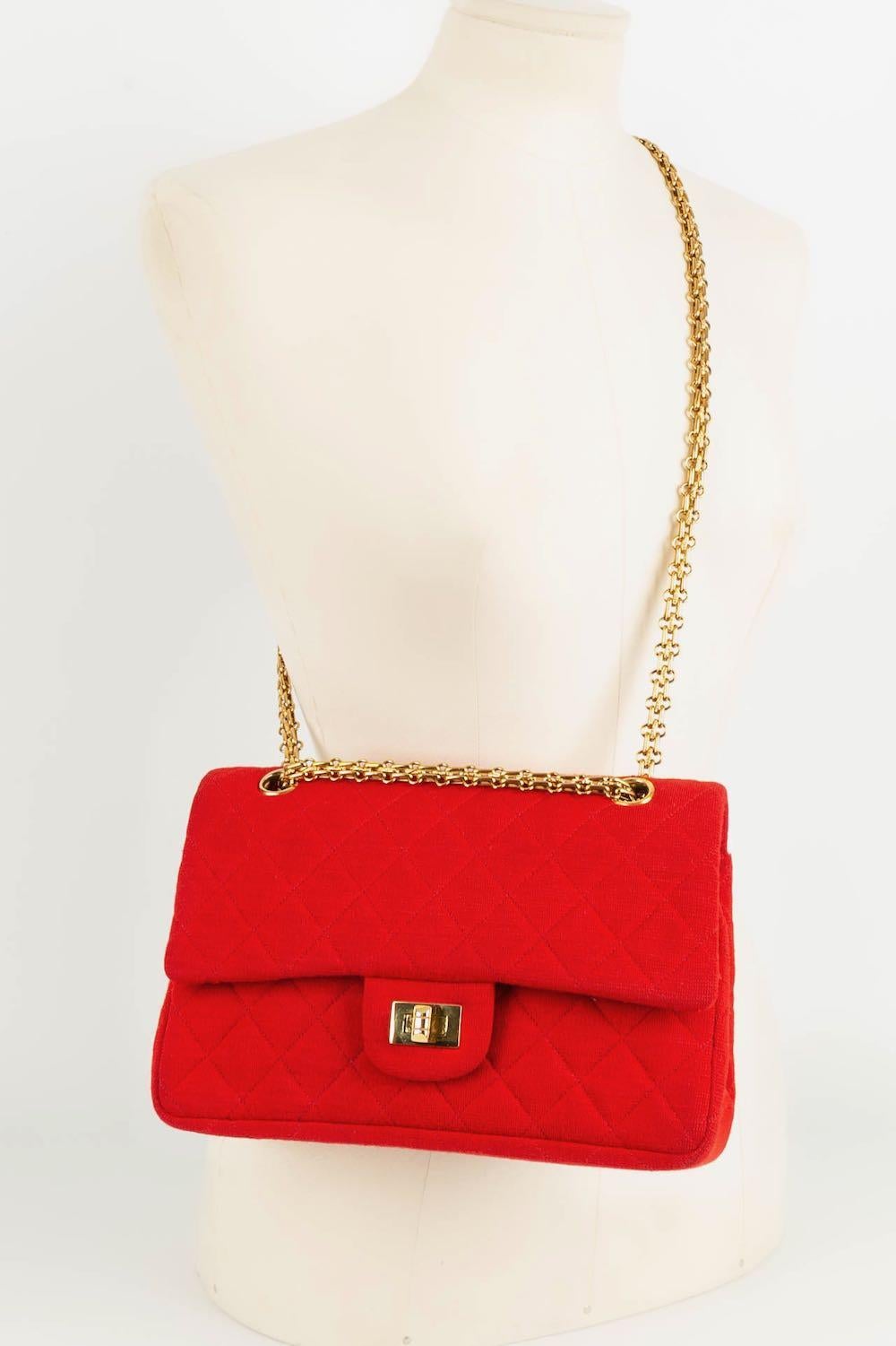 NOT SIGNED - Red quilted jersey bag with gold metal attributes.

Condition:
Very good condition

Dimensions:
Width: 25 cm - Height: 17 cm - Depth: 6 cm - Handle: 50 cm // 85 cm

SKU:S35
