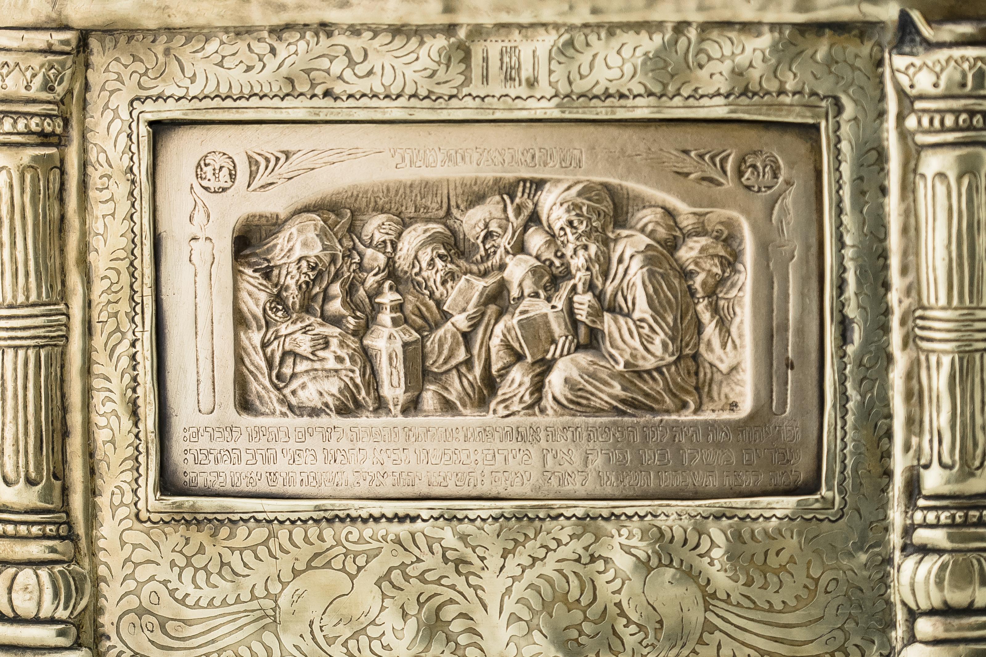 Framed plaque by Boris Schatz, Bezalel School, Jerusalem, circa 1915.
Depicting the scene of Tisha B’Av, Acid etched, hammered, and engraved frame, on top with two lions holding the Temple Menorah and the bottom engraved 