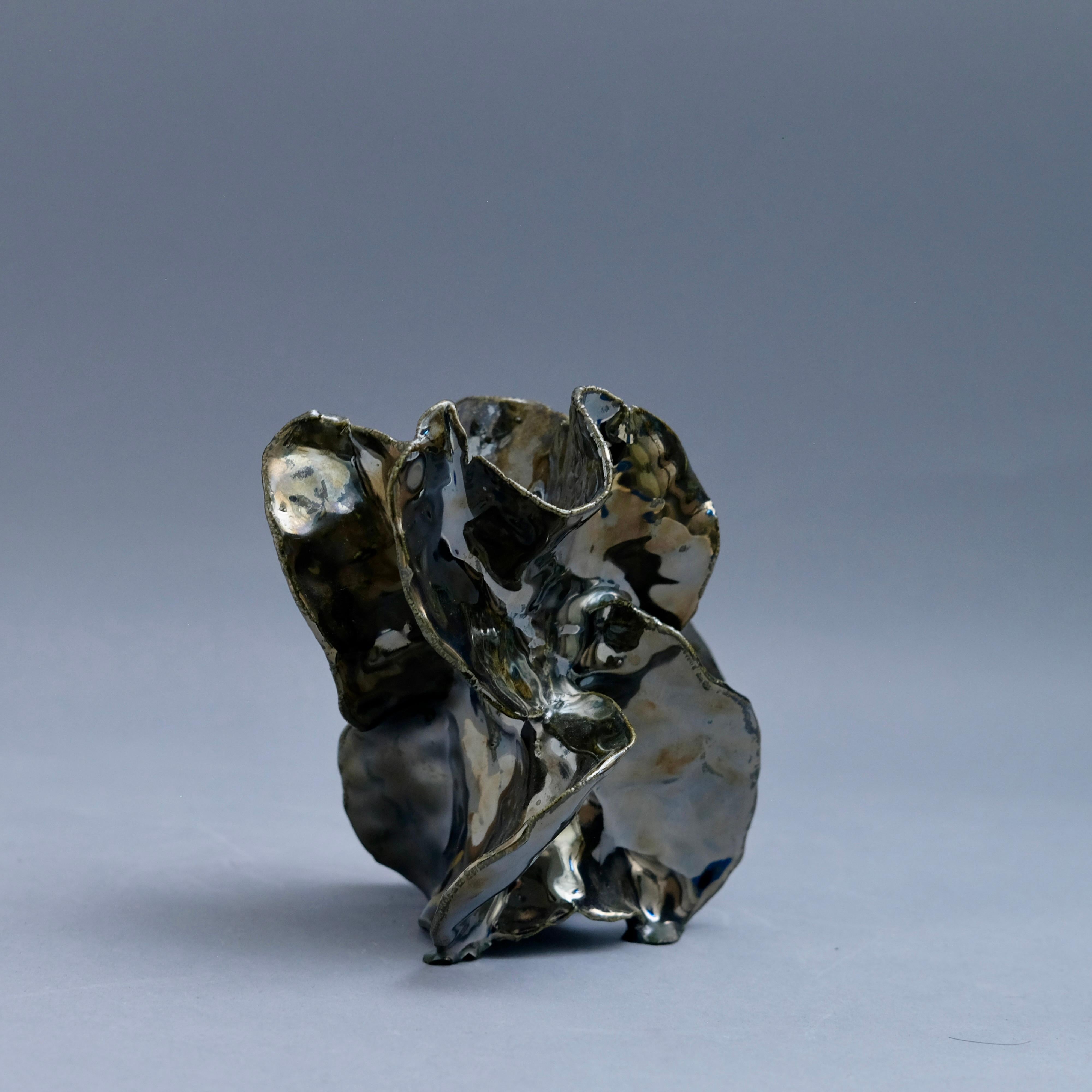 Vase-sculpture en céramique chromée métallique émaillée, taillée à la main, de Jessamyn Go.

Le travail de Jessamyn Go est profondément ancré dans l'expérience viscérale et méditative du travail de l'argile. Attirée par la sensation tactile de ses