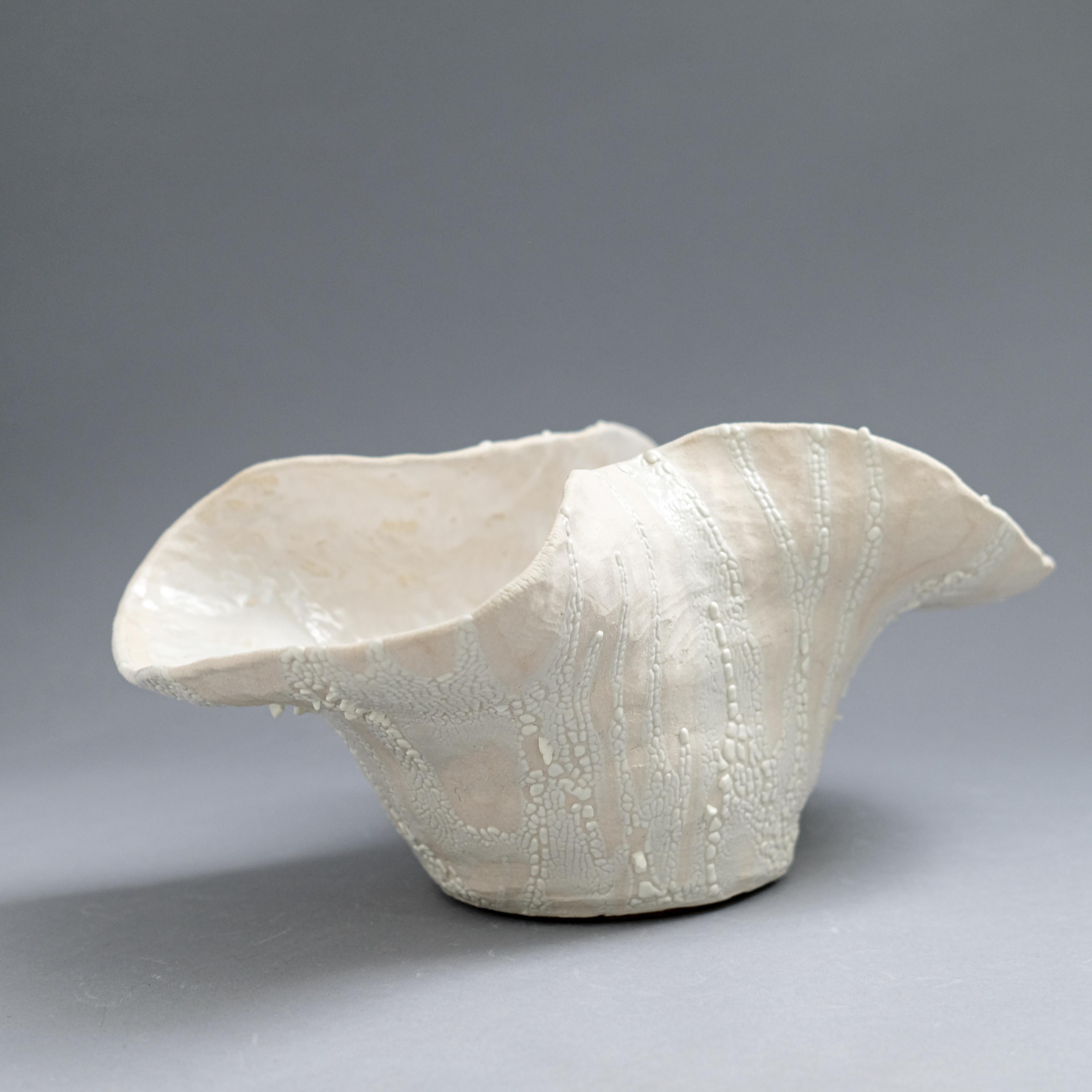 White stoneware, white crawl glaze, white glazed ceramic bowl sculpture by Jessamyn Go. Size: 5 high x 12 wide  x 7 inches deep

Jessamyn Go's work is deeply rooted in the visceral, meditative experience of working with clay. Drawn to the tactile