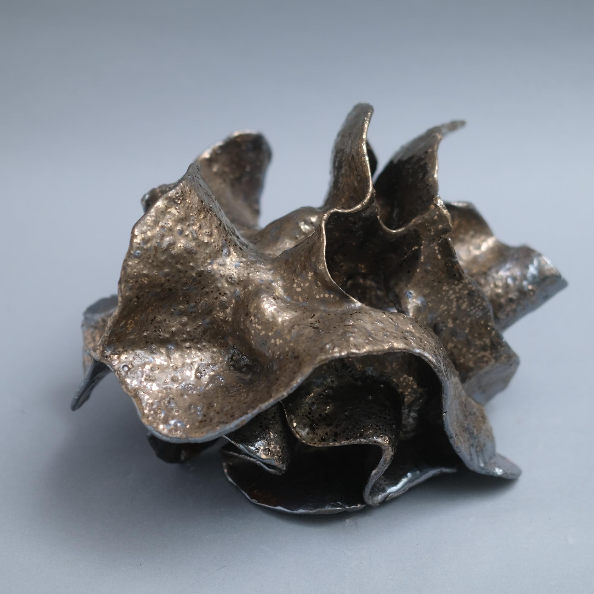 Sculpture en céramique de grès moucheté avec glaçure métallique, réalisée à la main par Jessamyn Go.

Le travail de Jessamyn Go est profondément ancré dans l'expérience viscérale et méditative du travail de l'argile. Attirée par la sensation tactile