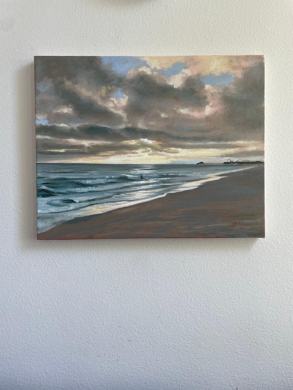 <p>Commentaires de l'artiste<br>L'artiste Jesse Aldana peint une vue spectaculaire du rivage de la baie de Santa Monica. Un surfeur s'aligne pour un dernier tour alors que le soir tombe sous de lourds nuages. Au loin, le carnaval de la jetée