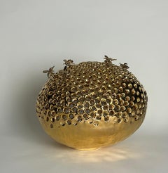 escultura de una colmena de cerámica patinada en oro puro, abejas de bronce