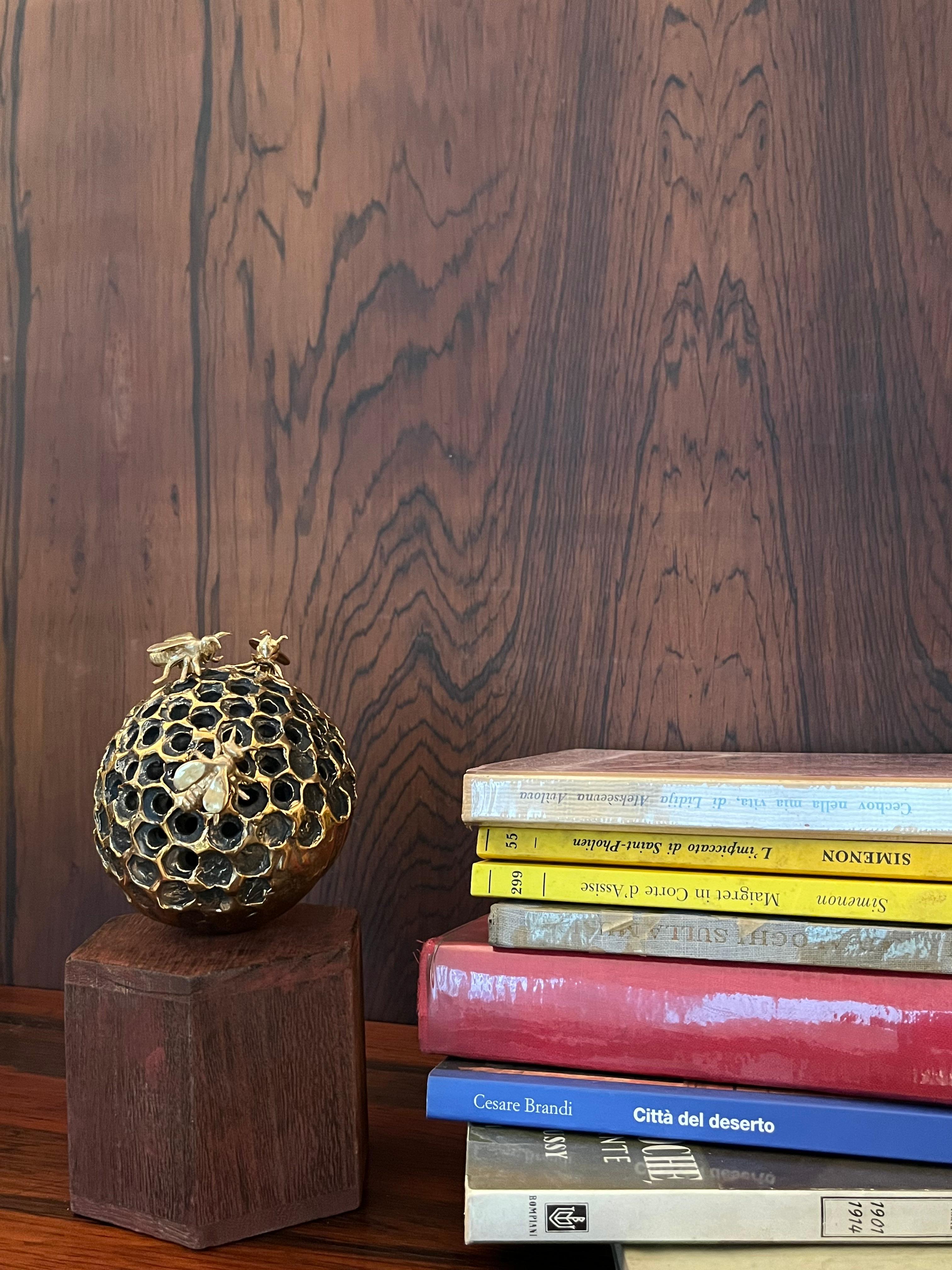 Una piccola e perfetta sfera in bronzo su base in legno è il supporto su cui poggiano tre api, anche esse in bronzo. Secondo lo spirito ludico di Jessica Carroll le api sono mobili ed è possibile spostarle e riposizionarle, instaurando ogni volta