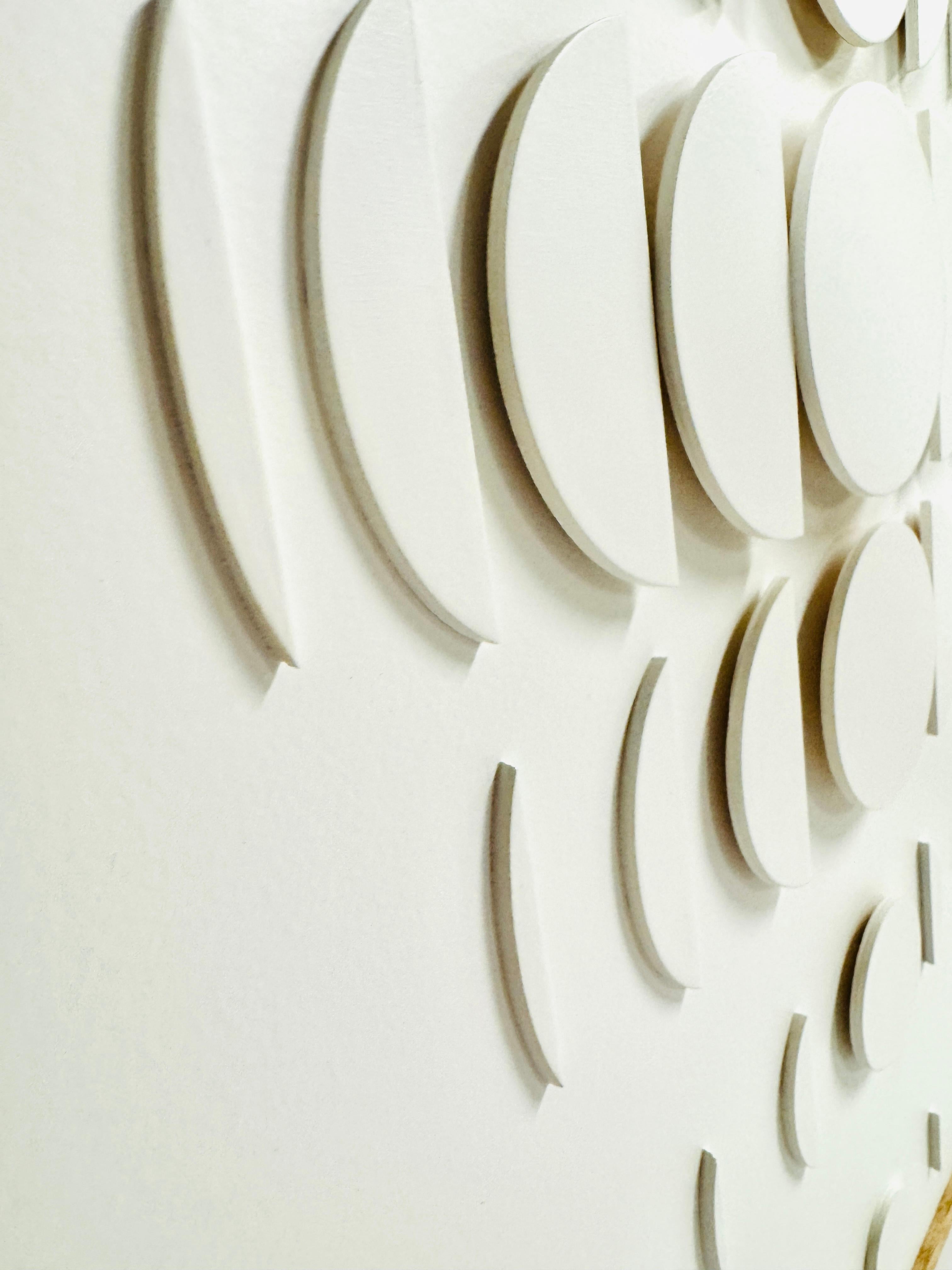 Diese weiße Holzarbeit von Jessie Laura spielt mit optischen Täuschungen, indem sie Weiß als minimalistische Palette und geometrische Formen verwendet, die auf einer Holzplatte geschichtet sind, um Tiefe zu erzeugen. Das Kunstwerk ist in einem