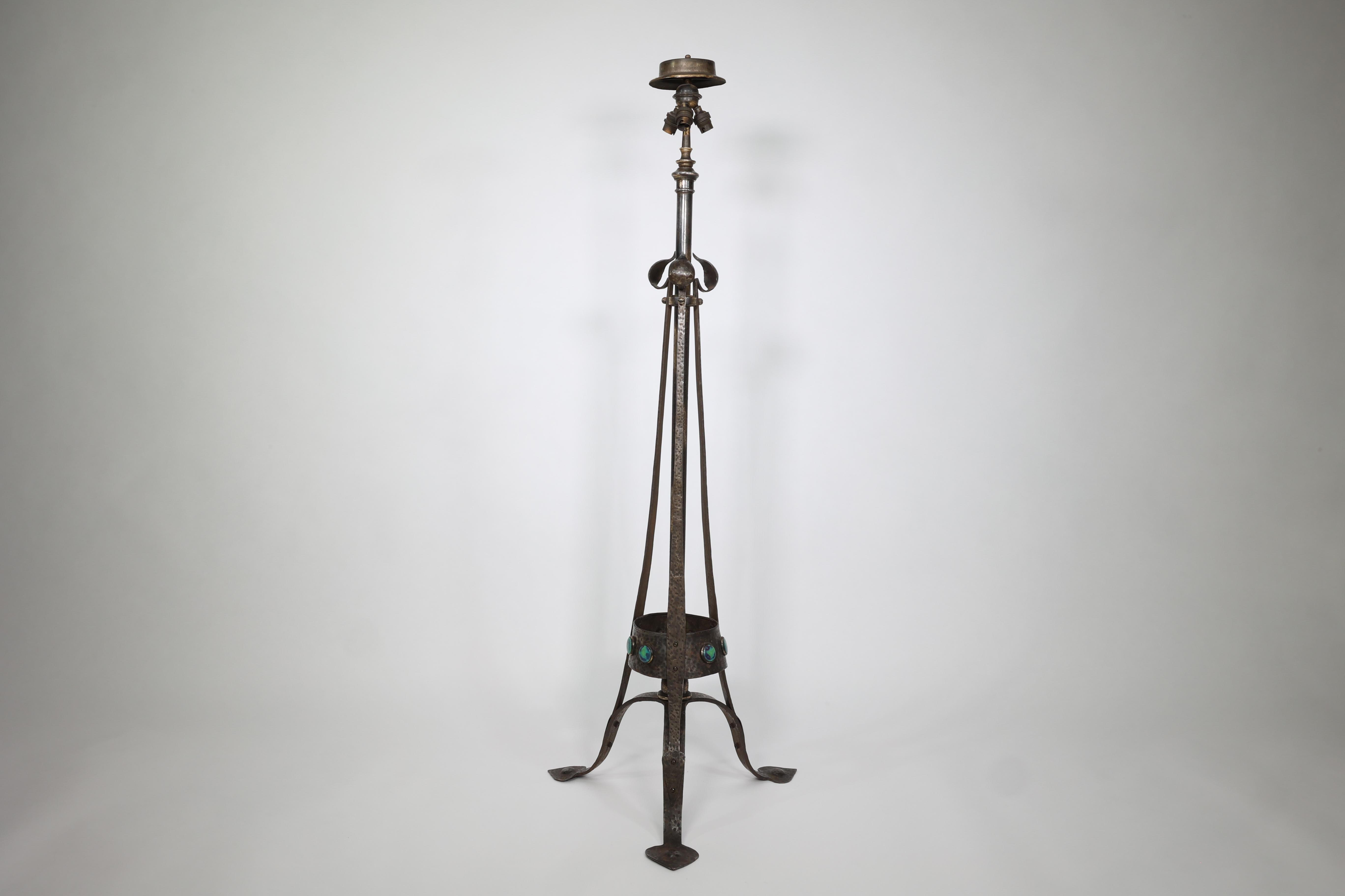 Jesson Birkett attributed. An Arts and Crafts hand hammered copper standard floor lamp with a circular lampshade holder to the top, a central telescopic post with three bulb holders, and three leaf details to the three hammered straps which come