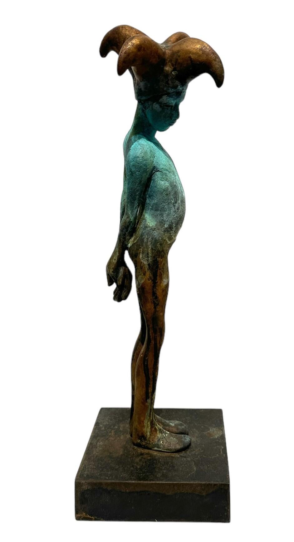 Ce petit bronze de Jesus Curia représente un arlequin coiffé d'un bonnet de bouffon à trois pointes qui se tient debout, défiant, le ventre à l'air et les mains jointes dans le dos.  La patine appliquée à la main ajoute au caractère unique de la
