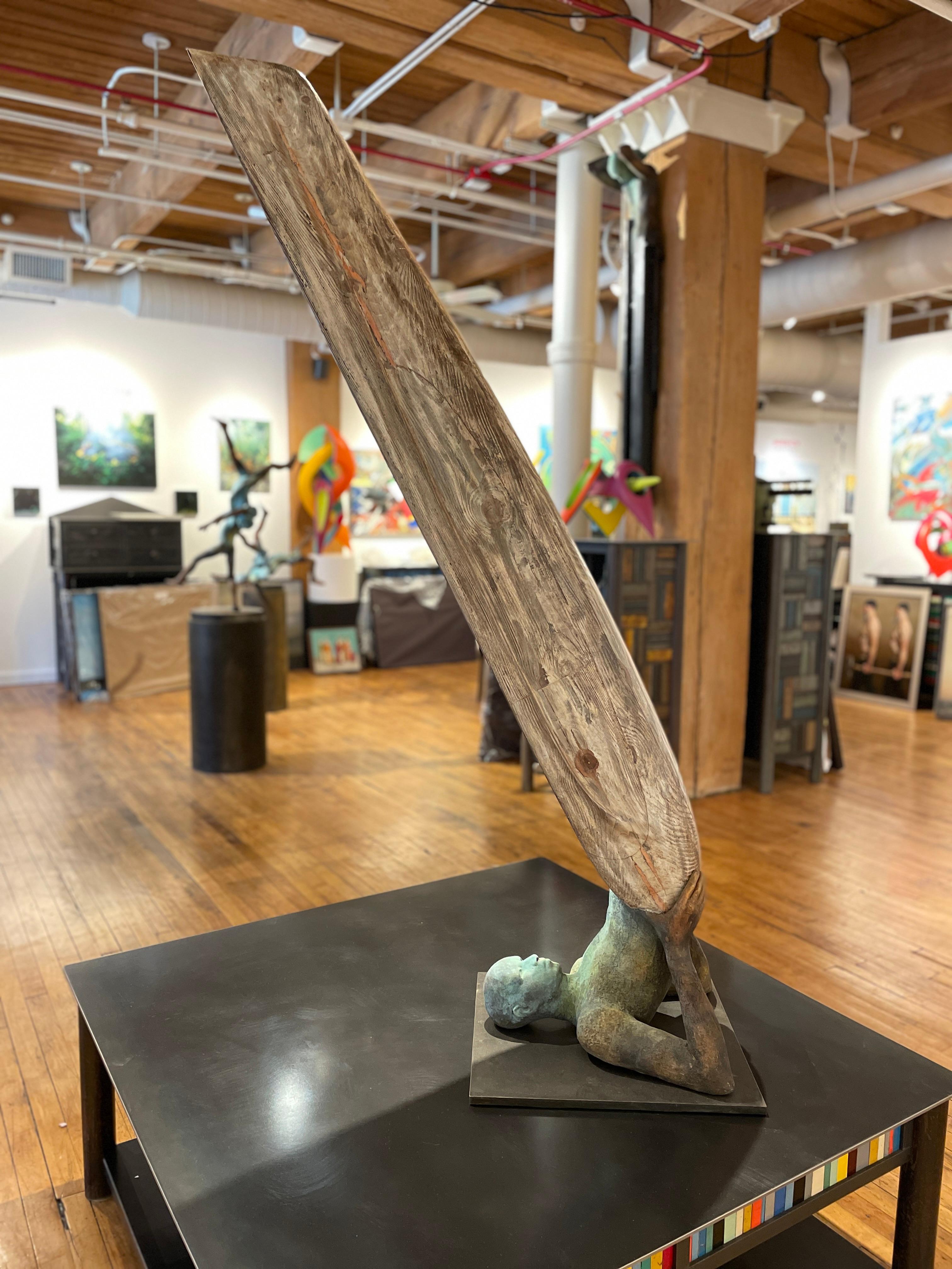 Inspired by the Shoulder Stand in Yoga, aka Sarvangasan, Curiá brings an abstraction to the pose as the figure's legs morph into a wooden boat.  The figure has a beautiful green patina that flows into a warm copper rust at its extremities, adding to