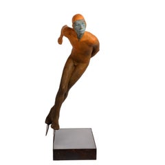 Deslizando - Escultura de bronce de una figura de patinaje de velocidad con traje naranja