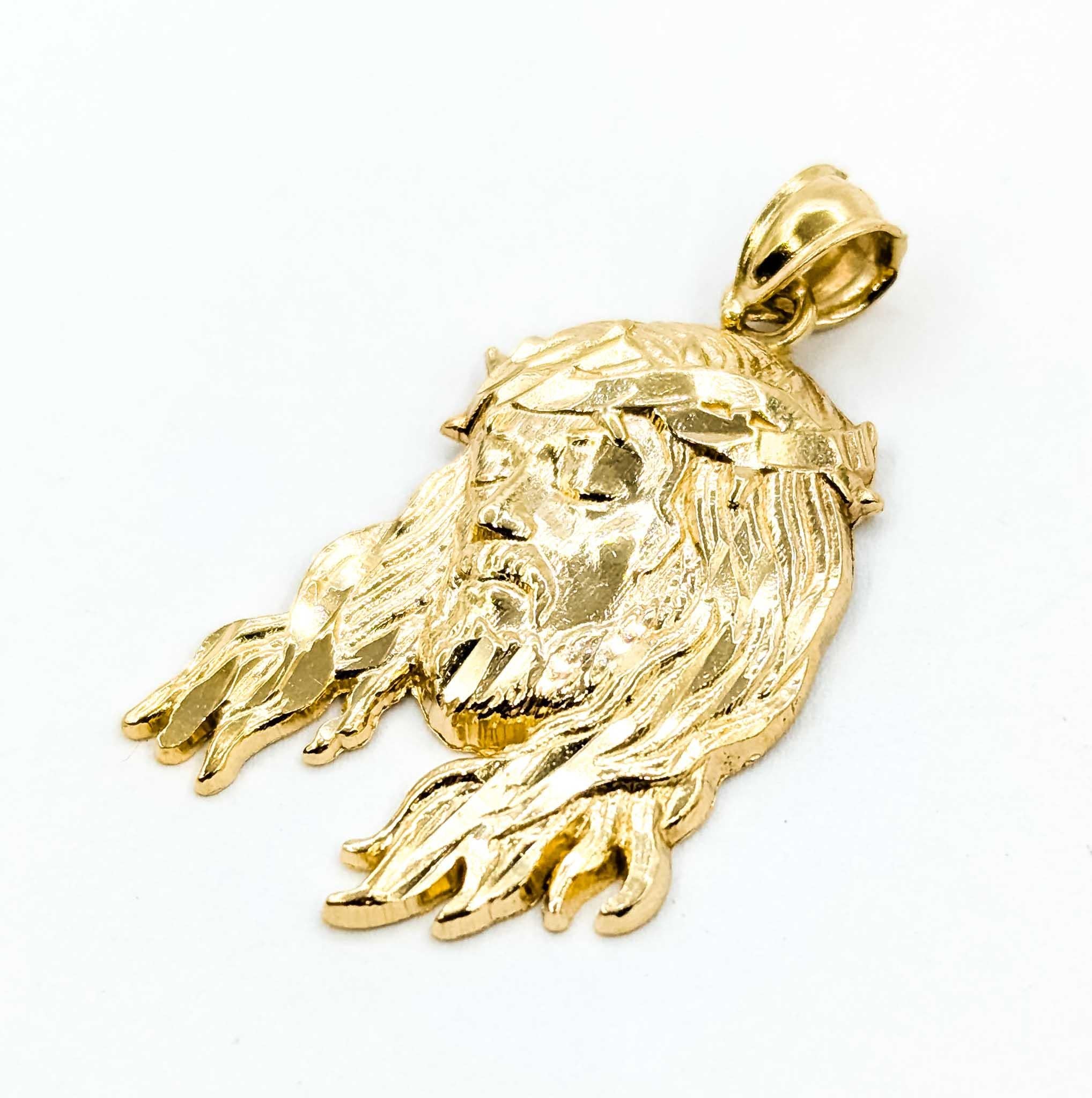 Questo significativo ciondolo è realizzato in oro giallo 14k e raffigura il volto di Gesù che indossa la corona di spine, simbolo di sacrificio e devozione. La lavorazione dettagliata mette in risalto i suoi capelli fluenti e la sua espressione