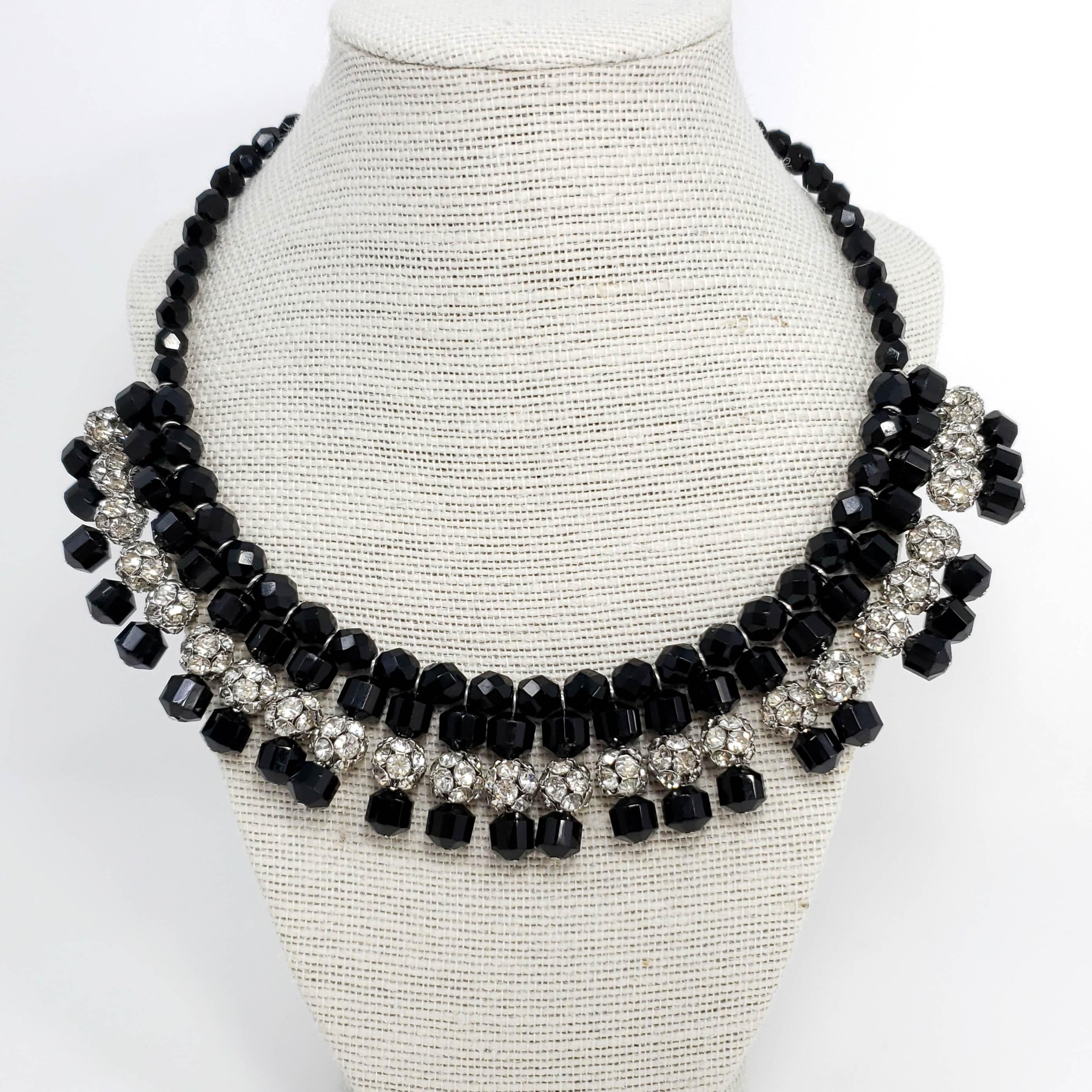 A vintage collar necklace featuring faceted jet-black glass beads accented with silvertone pave-crystal balls. 

The necklace is on a silver tone metal wire which curls naturally. Hook closure.
