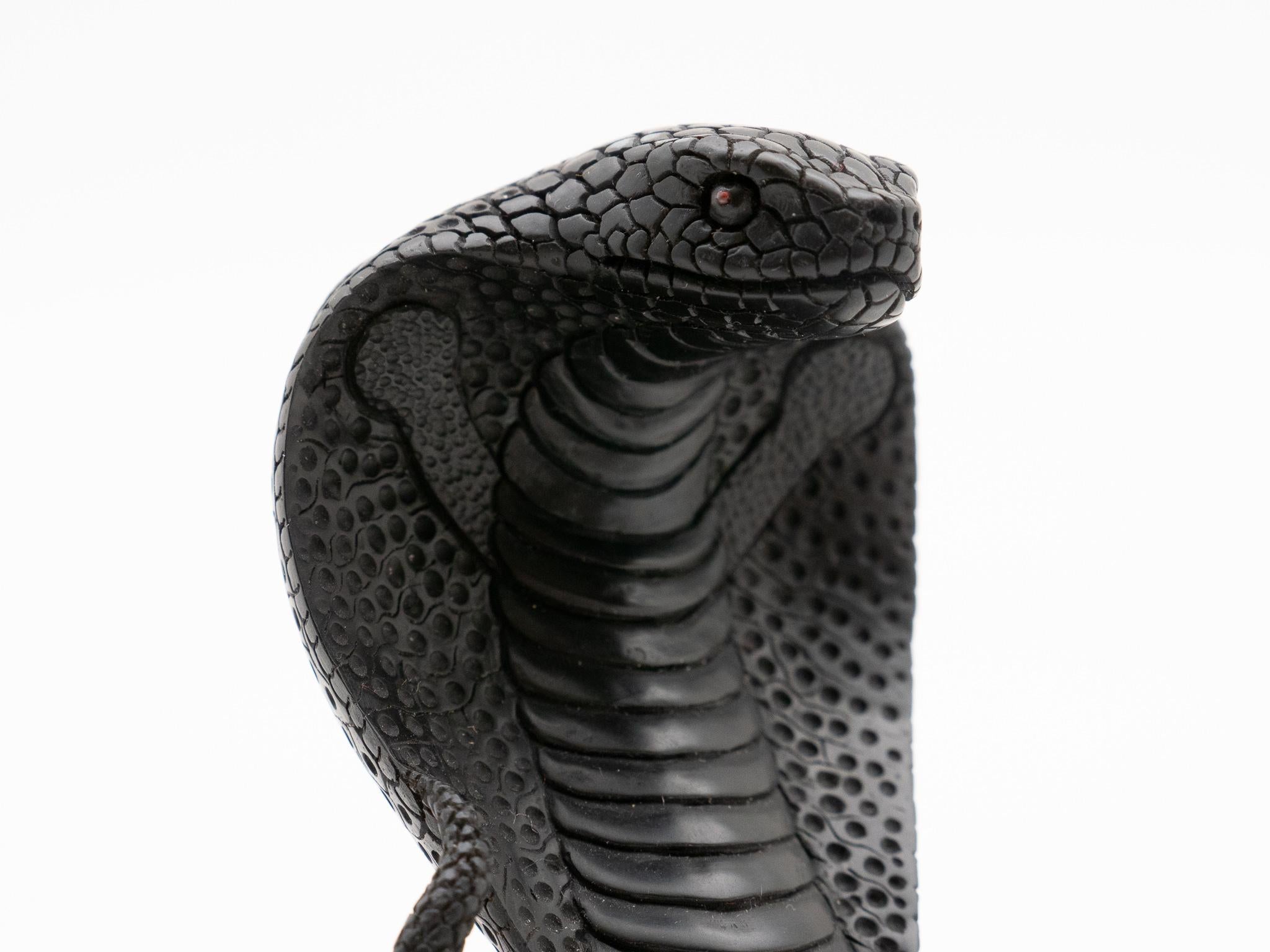 Hand-carved, highly detailed jet carving of a hooded cobra. Jet is a semiprecious gemstone produced by high-pressure decomposition of wood from millions of years ago.