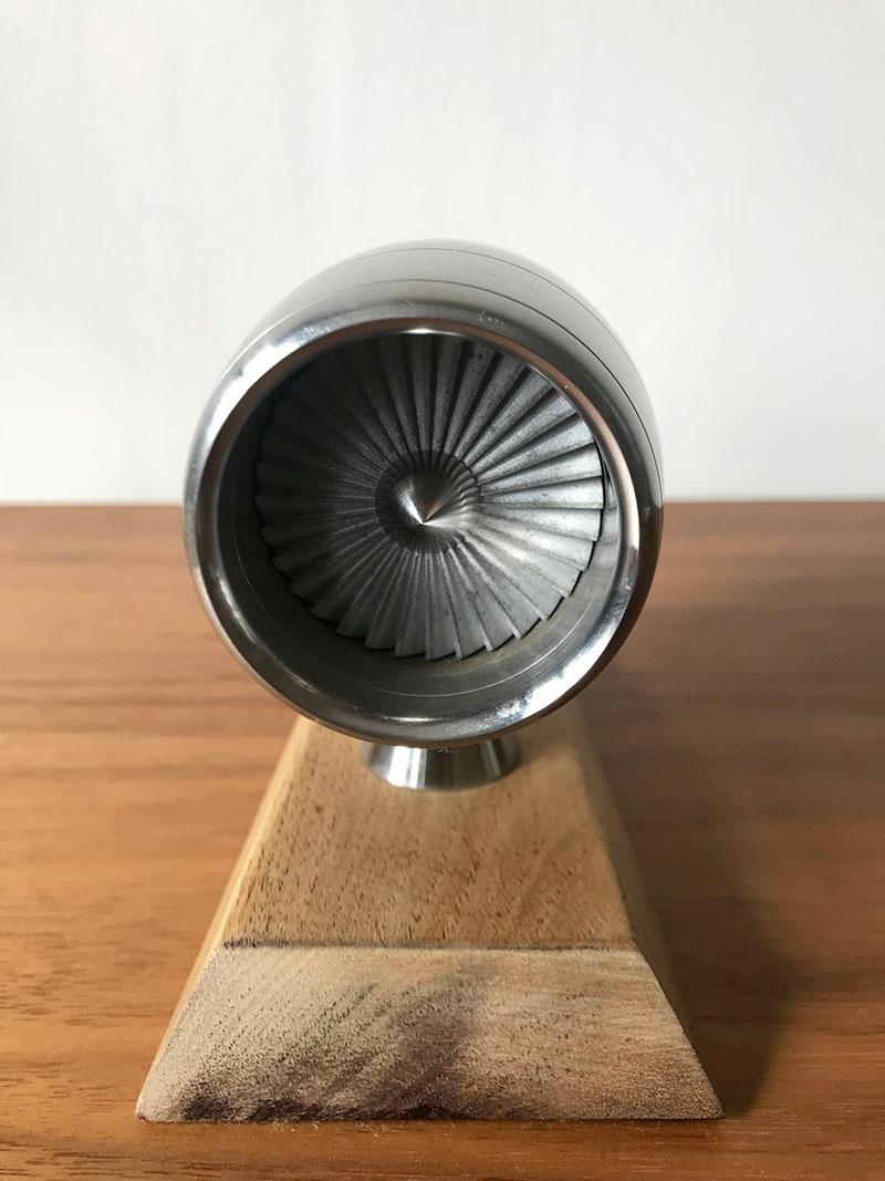 Engineers model of jet turbine in cowling.

A hand built model of a jet engine with spinning turbine. Mounted on a wooden stand. Possibly built by an apprentice working within the airline workshop.

 