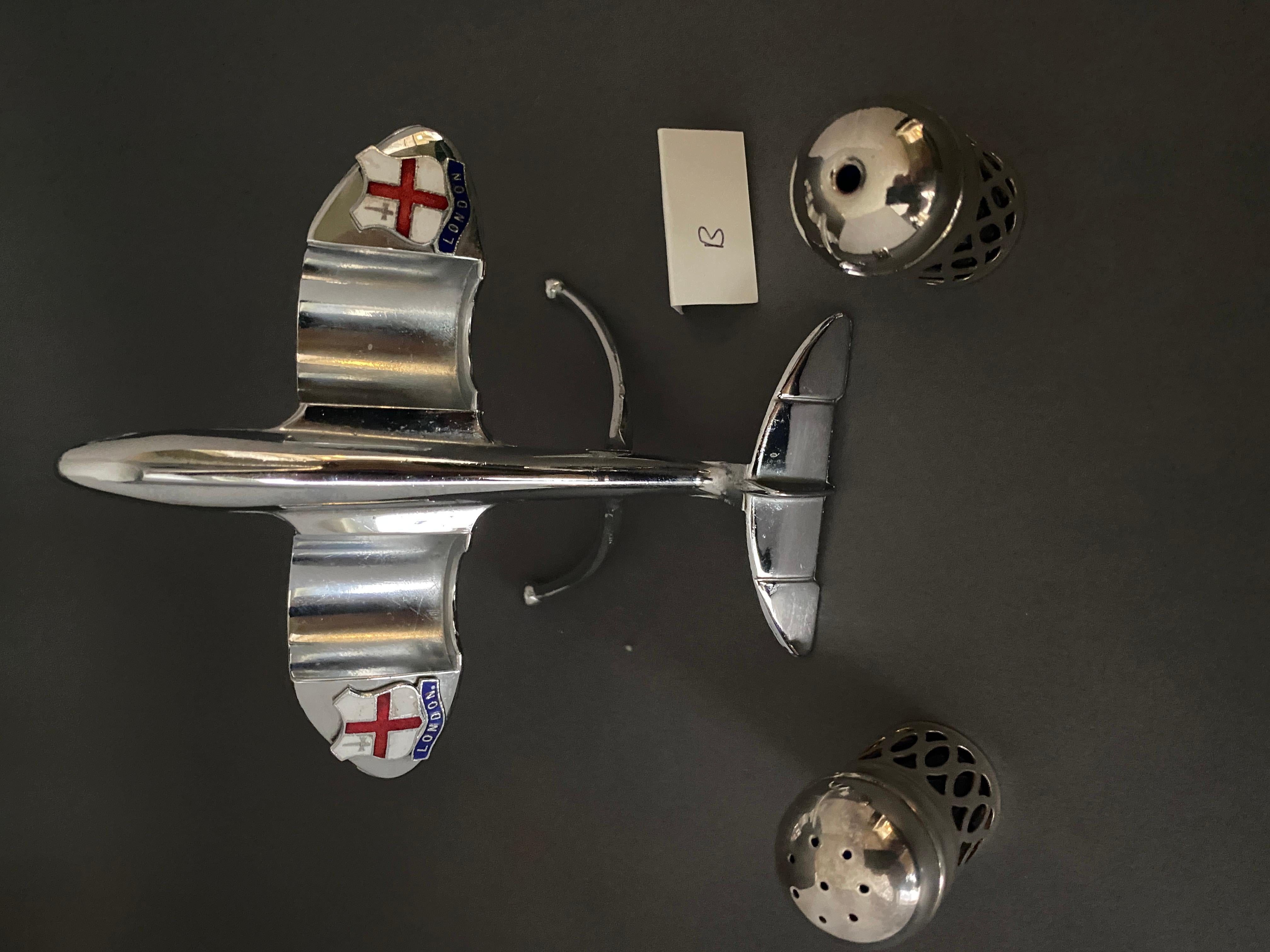 Jet Plane Novelty Cruet set 1950s [B].
Avion chromé sur pied,
Les pots de sel et de poivre s'accrochent aux ailes
agissant comme des moteurs à réaction, 
Papiers bleus de Bristol,
Insignes en émail sur les ailes Écusson de Londres
[Souvenir de