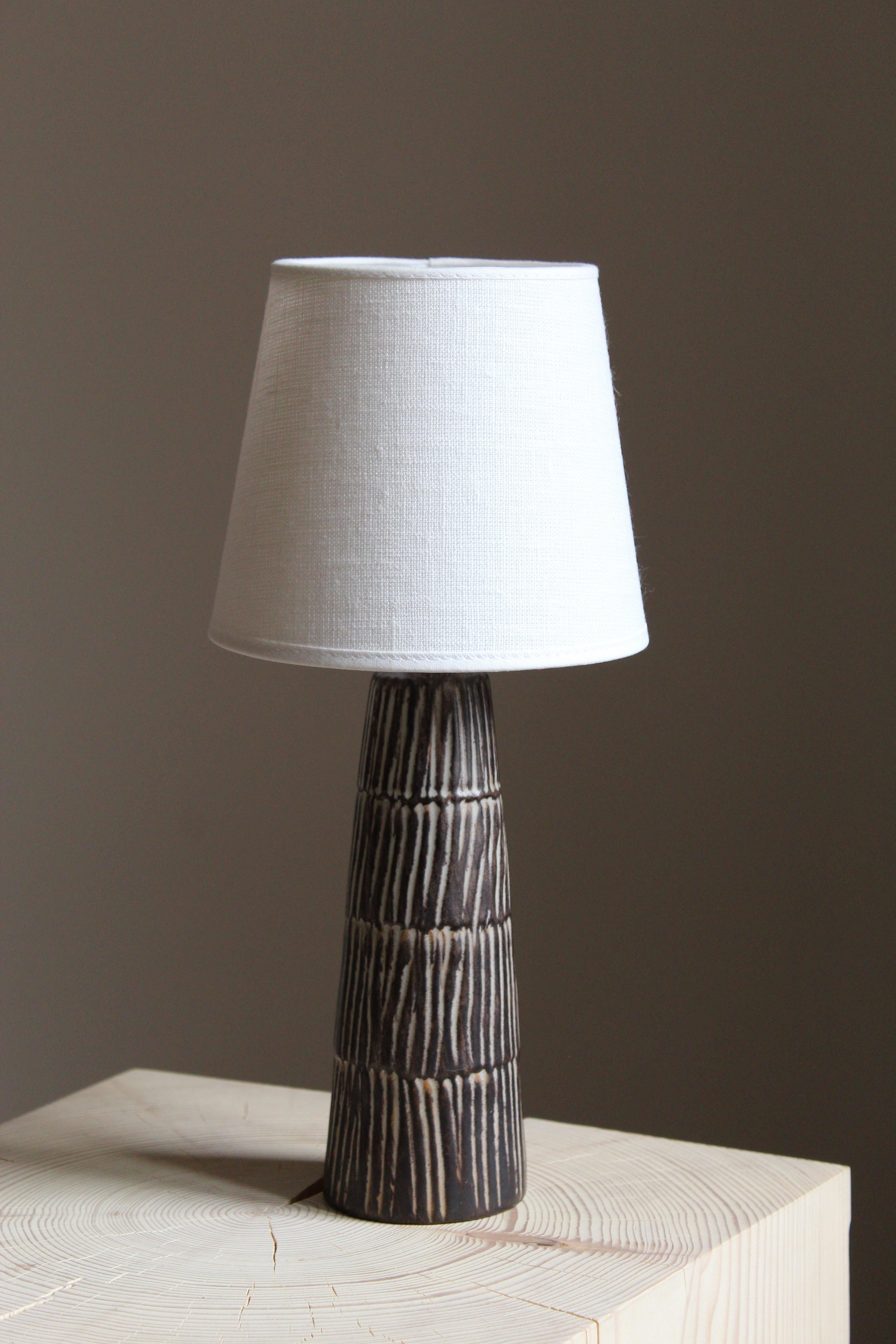 A stoneware lamp, produced by Jette Hellerøe, Denmark 1950, signed. Sold without lampshade.

Glaze features brown-grey colors.

Other ceramicists of the period include Axel Salto, Wilhelm Kåge, Arne Bang, Claude Connover, and Carl-Harry Stålhane.