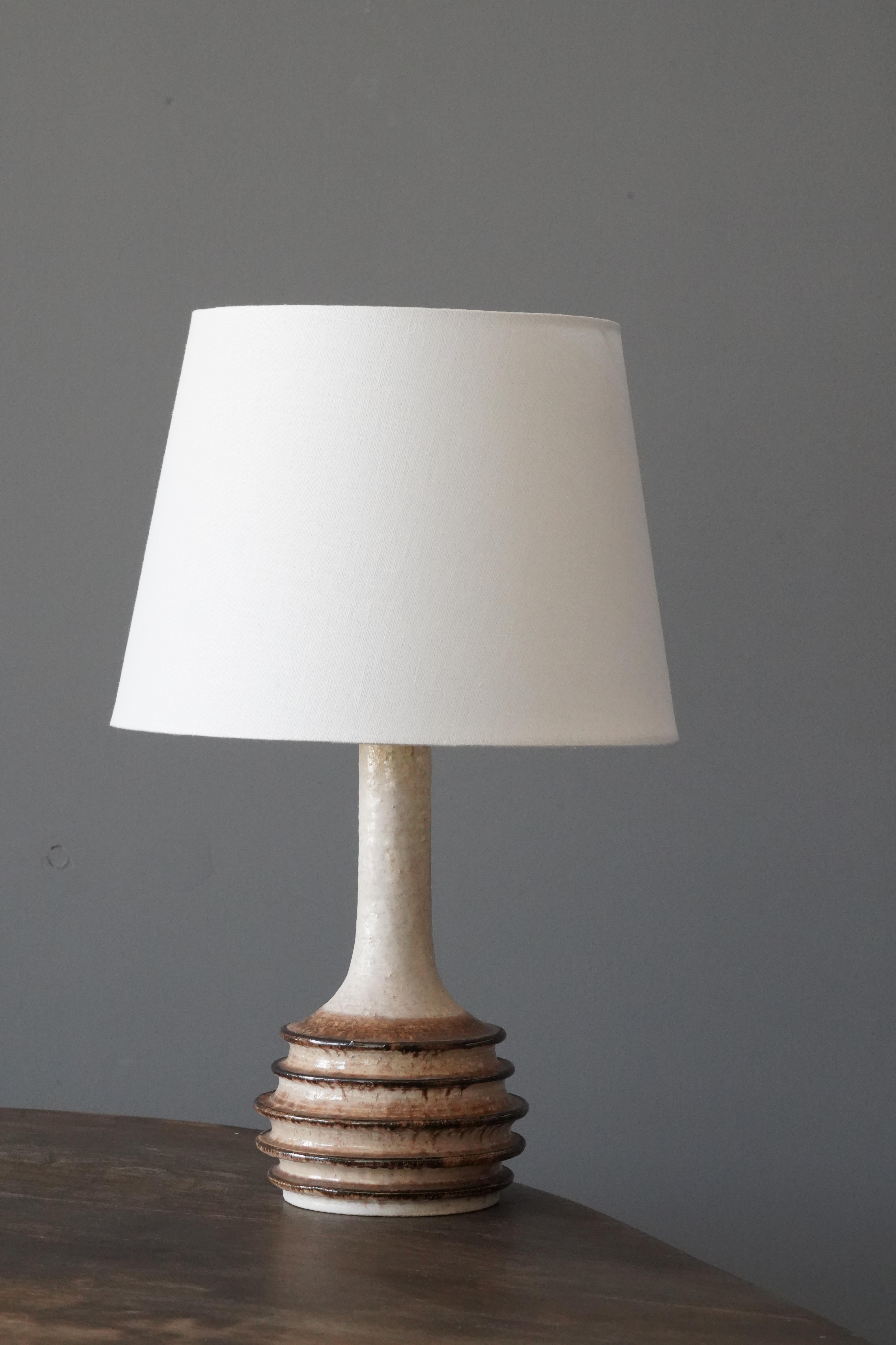 A stoneware lamp, produced by Jette Hellerøe, Denmark 1960, signed. 

Sold without lampshade. Dimensions exclude lampshade, height includes socket.

Glaze features white-brown colors.

Other ceramicists of the period include Axel Salto, Wilhelm