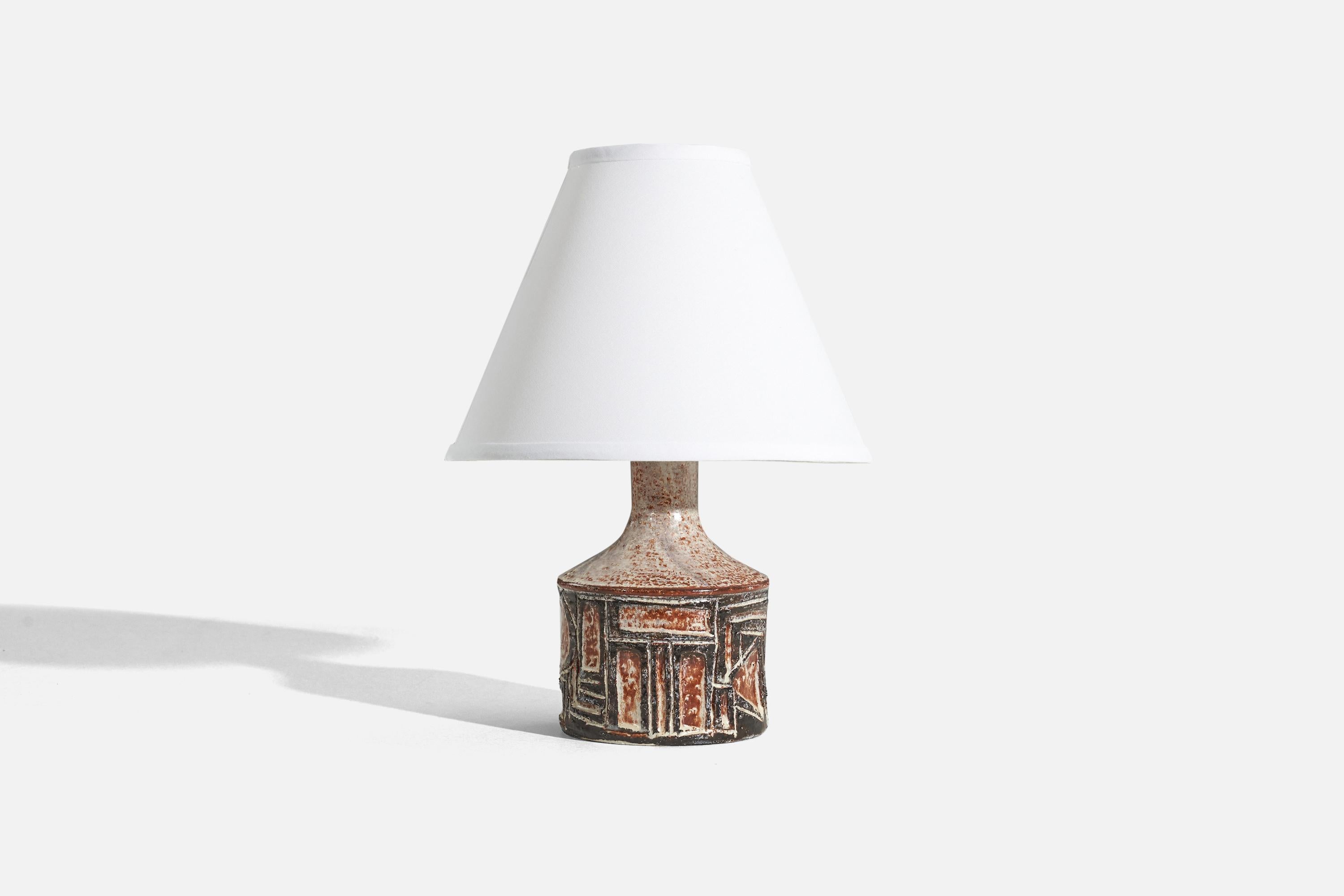 A black and red, glazed stoneware table lamp designed and produced by Jette Hellerøe, Denmark, 1960s.

Sold without lampshade. 
Dimensions of Lamp (inches) : 9.875 x 4.875 x 4.875 (H x W x D)
Dimensions of Shade (inches) : 4.25 x 10.25 x 8 (T x B x