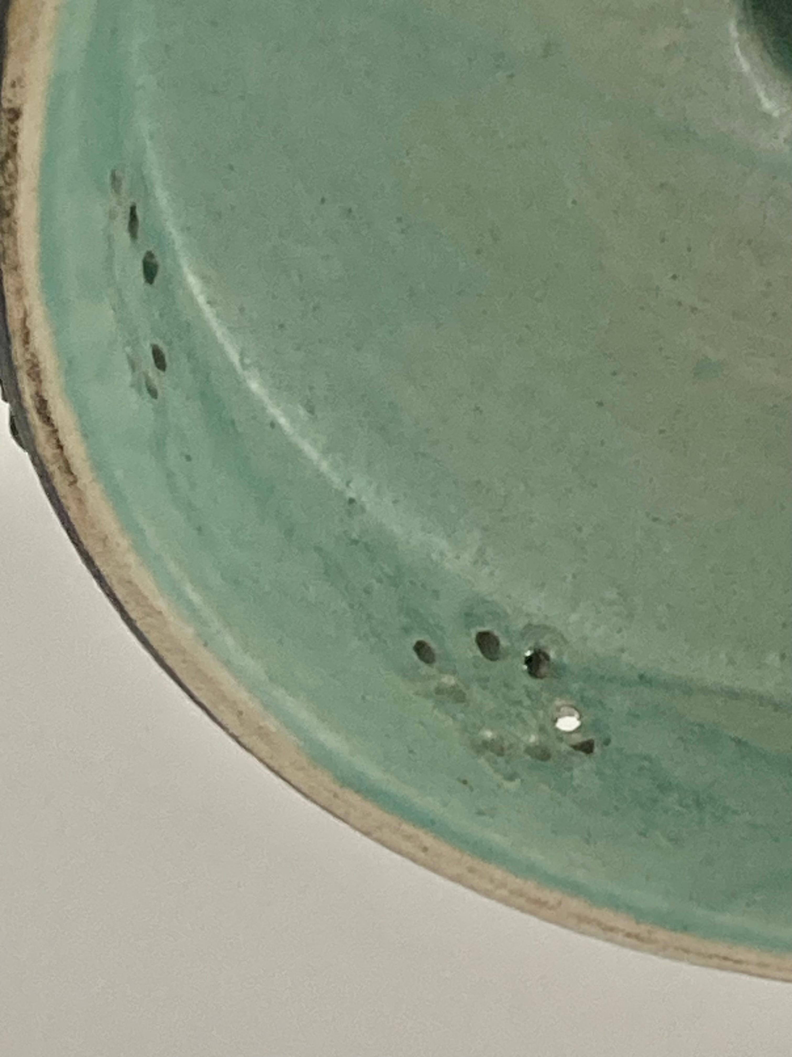 The canopy is in ceramic and the brass which is in brass is adjustable. So the dimensions  can be appropriate to the length you need.
This is an iconic danish pendant from  Jette Helleroe. The colors are a warm brown and green and the interior