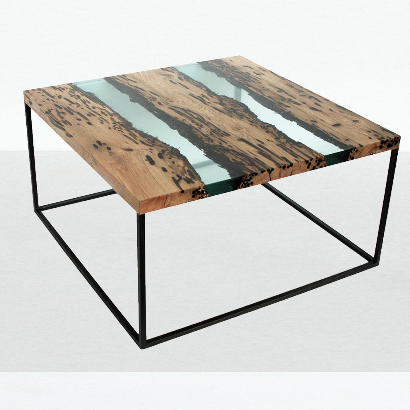 This elegant coffee table has a fine steel structure on which the top rests, creating a floating space where wood and water coexist. The reclaimed vintage oak wood of the many poles of the Venetian laguna is preserved in a special transparent resin