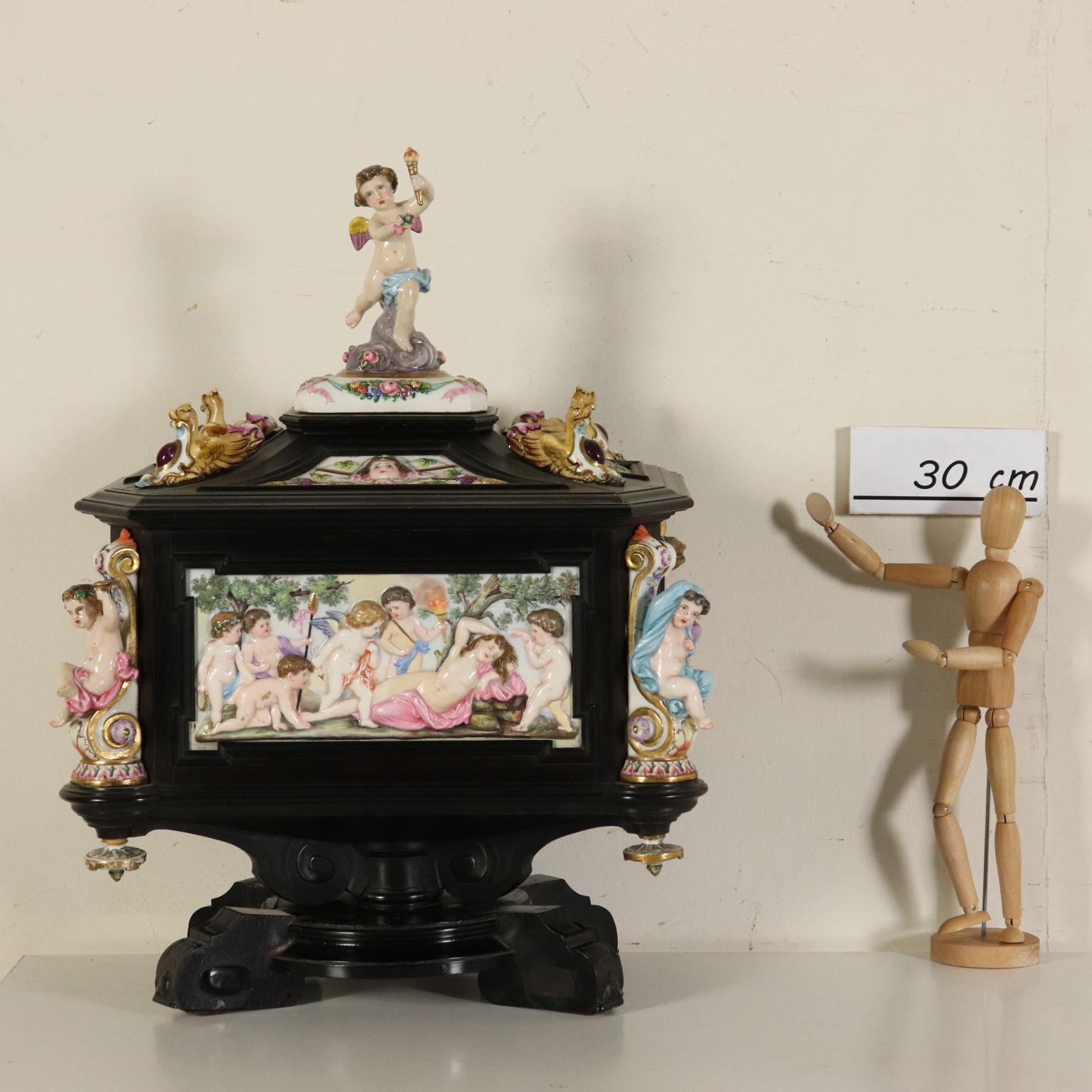 Jewel box made of ebony and Capodimonte porcelain. Swivel turned basement with four carved and ebonized bracket feet. The walnut box is completely veneered and covered with frames made of ebony. Inside, three small mahogany drawers veneered with