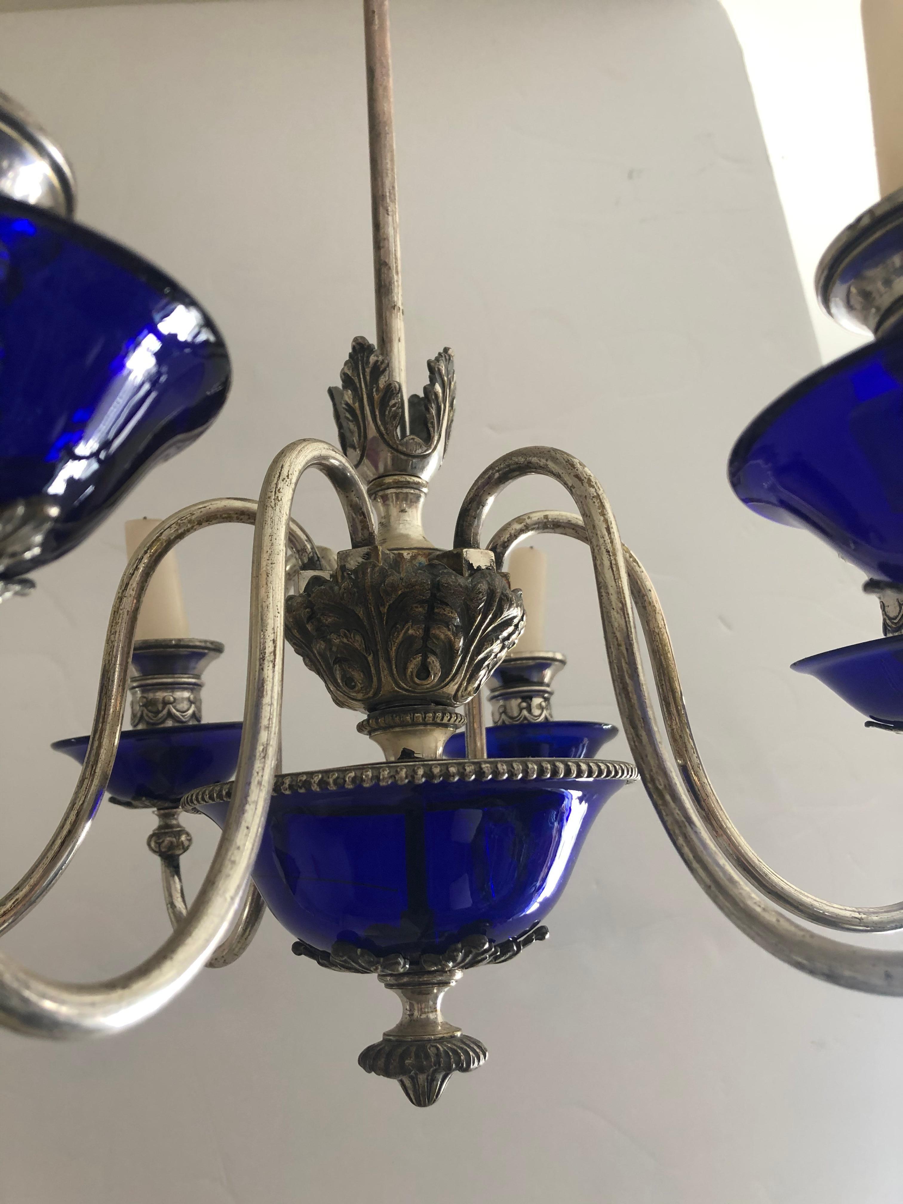 A rare jewel of a chandelier having a gorgeous mix of hallmarked silver plate and glistening cobalt blue glass. The 6 arms are currently for candles, but could easily be electrified for additional cost.
18