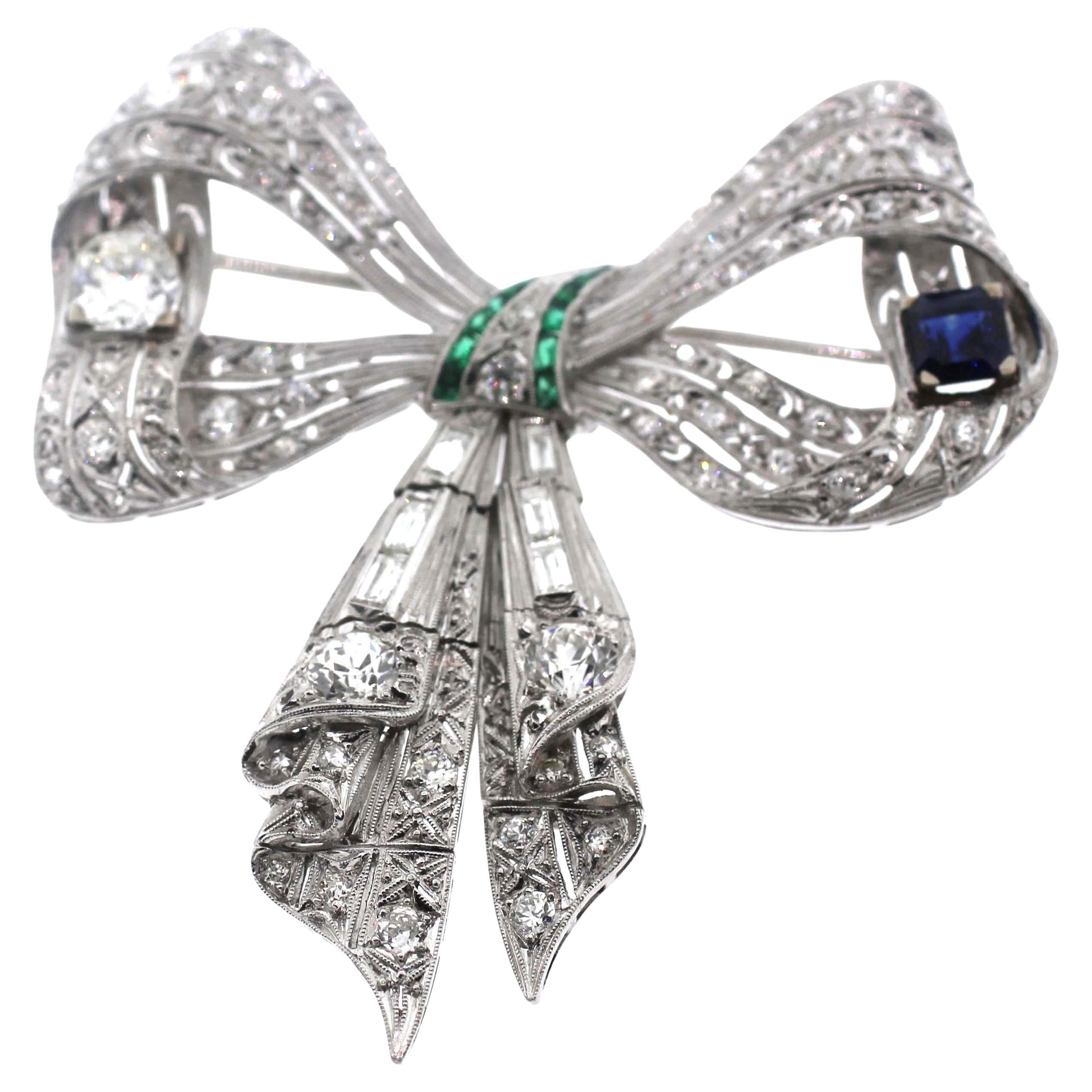 Platinum Diamonds, Sapphire and Emerald Bow Brooch Pendent
Gold Chain is not included