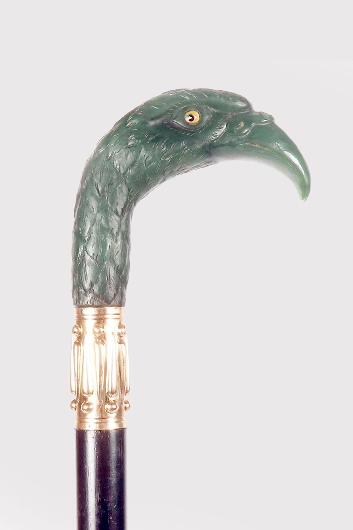 Canne : canne en bijou, pommeau en jade néphrite sculpté, représentant une tête d'aigle, yeux en pâte de verre, bandeau en or 18K et barillet en bois d'ébène. Signé André Aucoc (1856-1911). André Aucoc faisait partie de l'entreprise Aucoc fondée en
