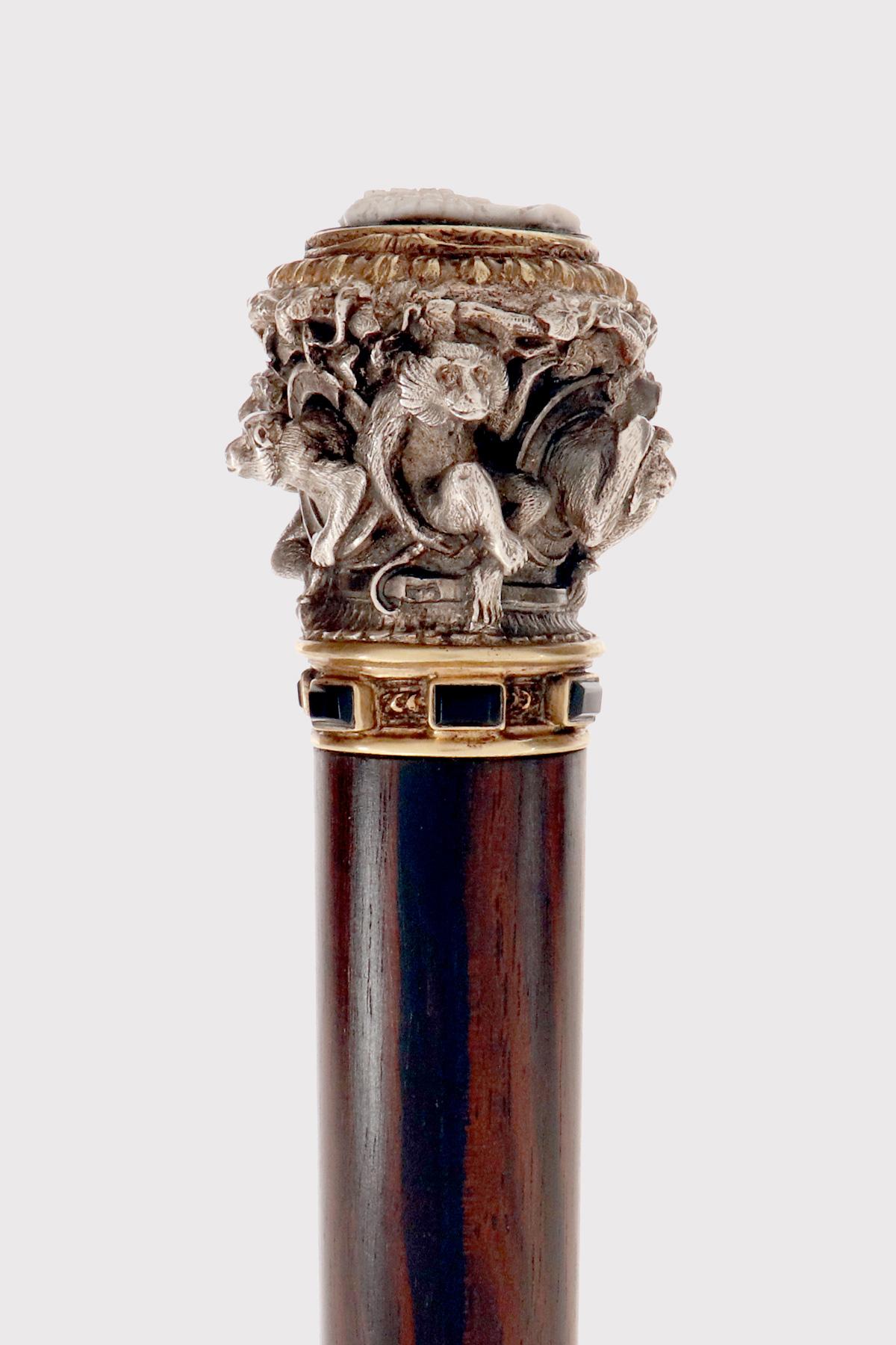 Bastón enjoyado, de plata, diseñado y ejecutado por François-Désiré Froment-Meurice. El pomo representa seis monos tallados y agachados. El terminal tiene un camafeo ovalado de ágata bicapa con una efigie blanca sobre fondo negro, que representa el