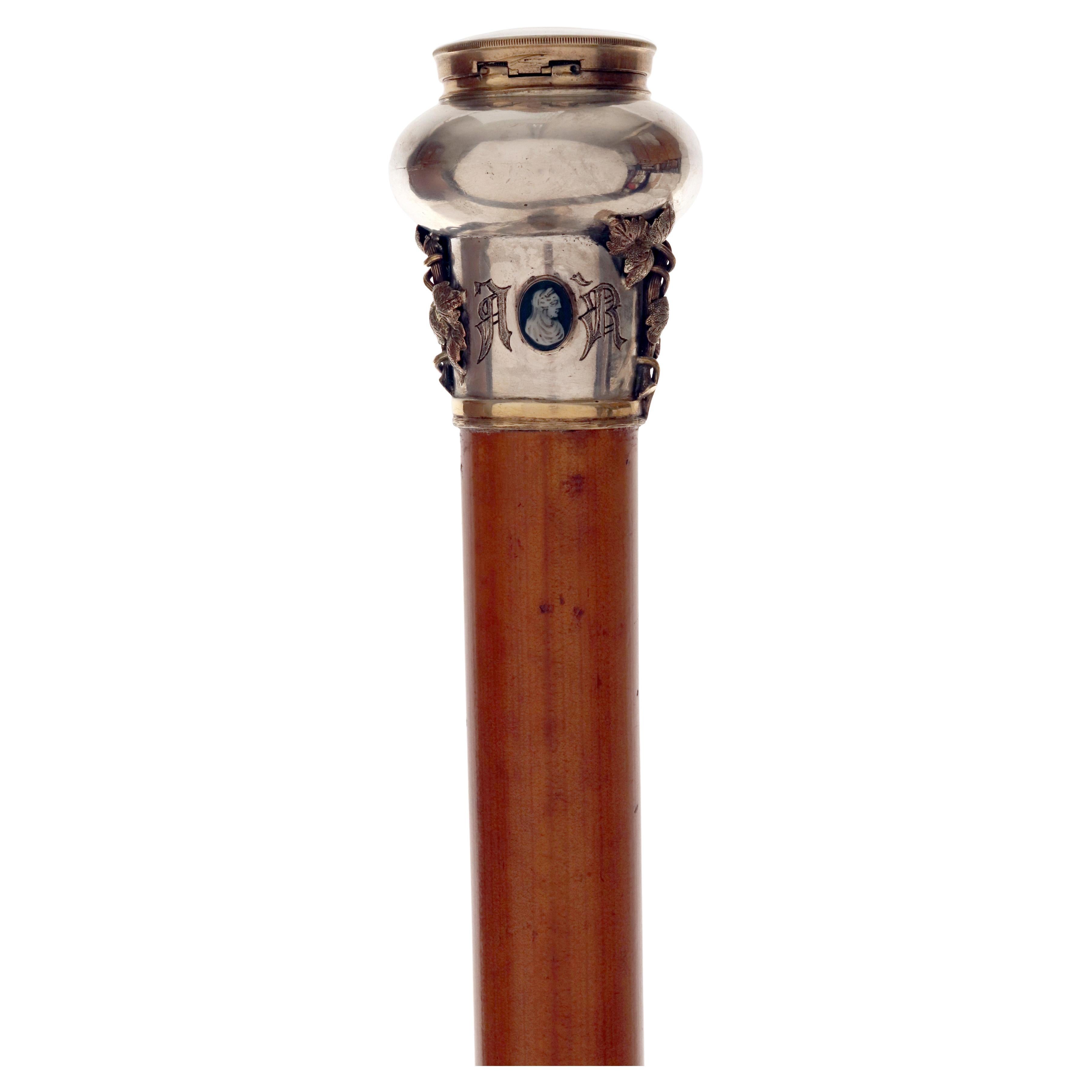 Canne en argent et en or ornée de bijoux, conçue et fabriquée par François-Désiré Froment-Meurice. Le pommeau est orné d'une horloge de fabrication française avec balancier apparent, entourée d'une bande d'or. Le bandeau inférieur présente deux